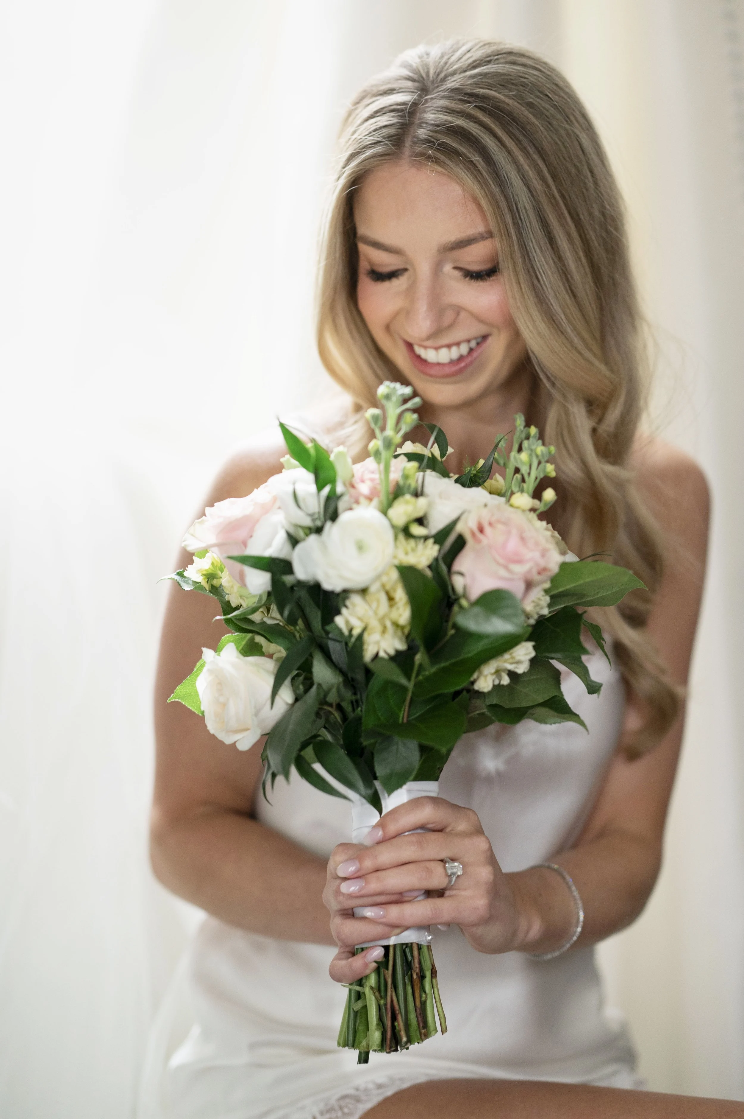 bride in her pijamas holding he bouquet on her wedding day getting ready at the park plaza hotel