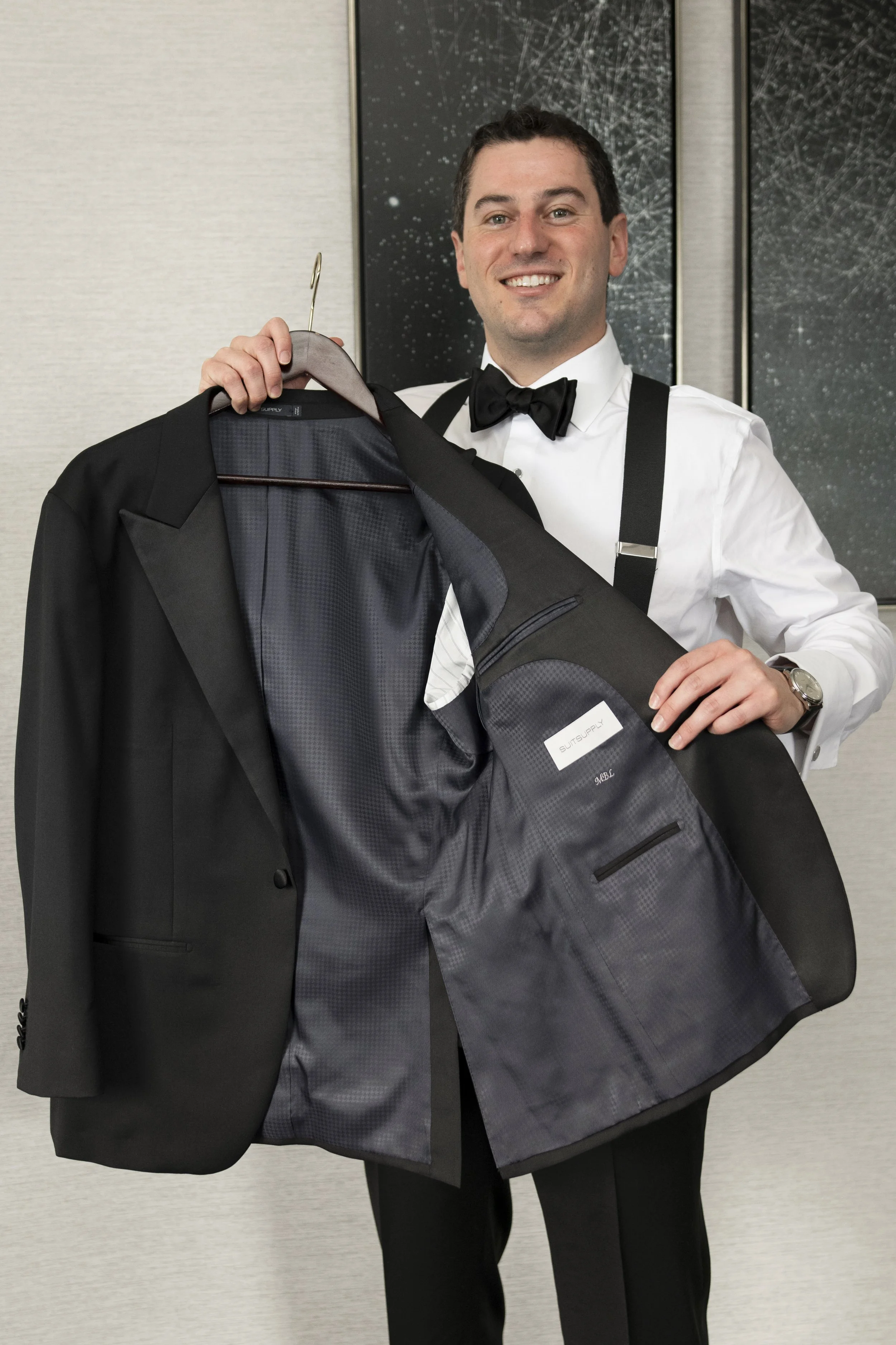 groom holding his jacket as he gets ready