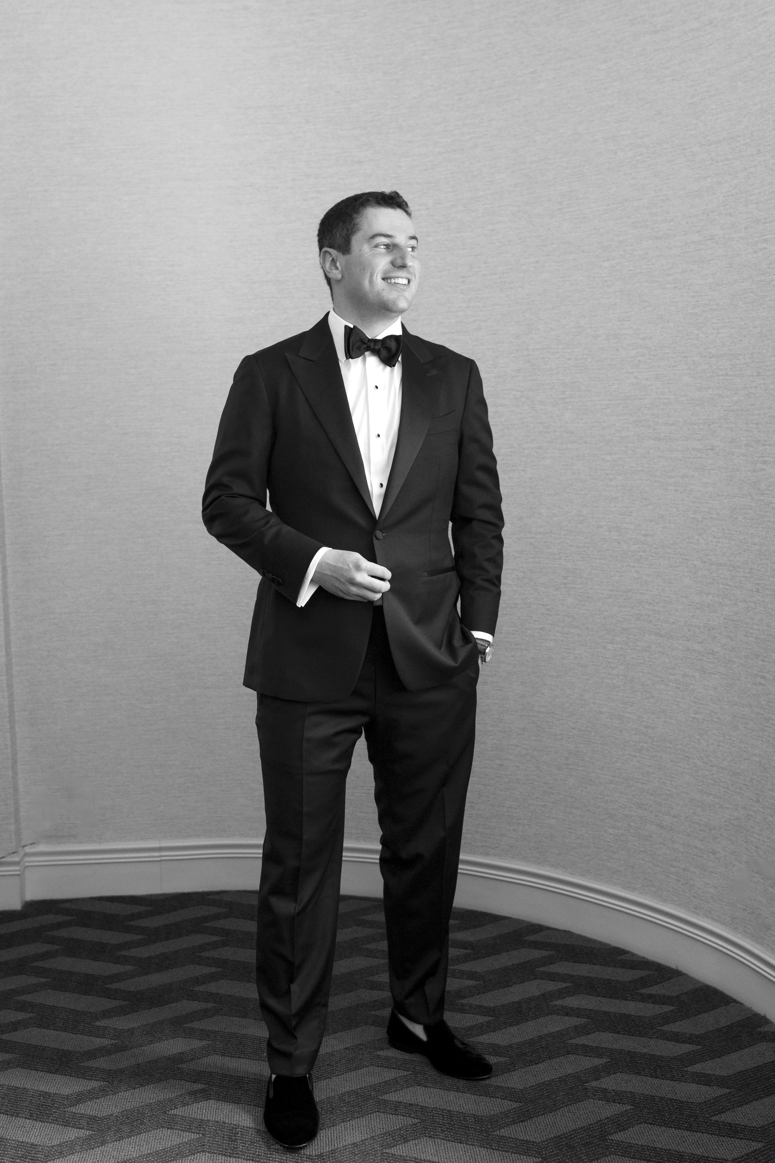 portrait of groom posing as he fix his tuxedo