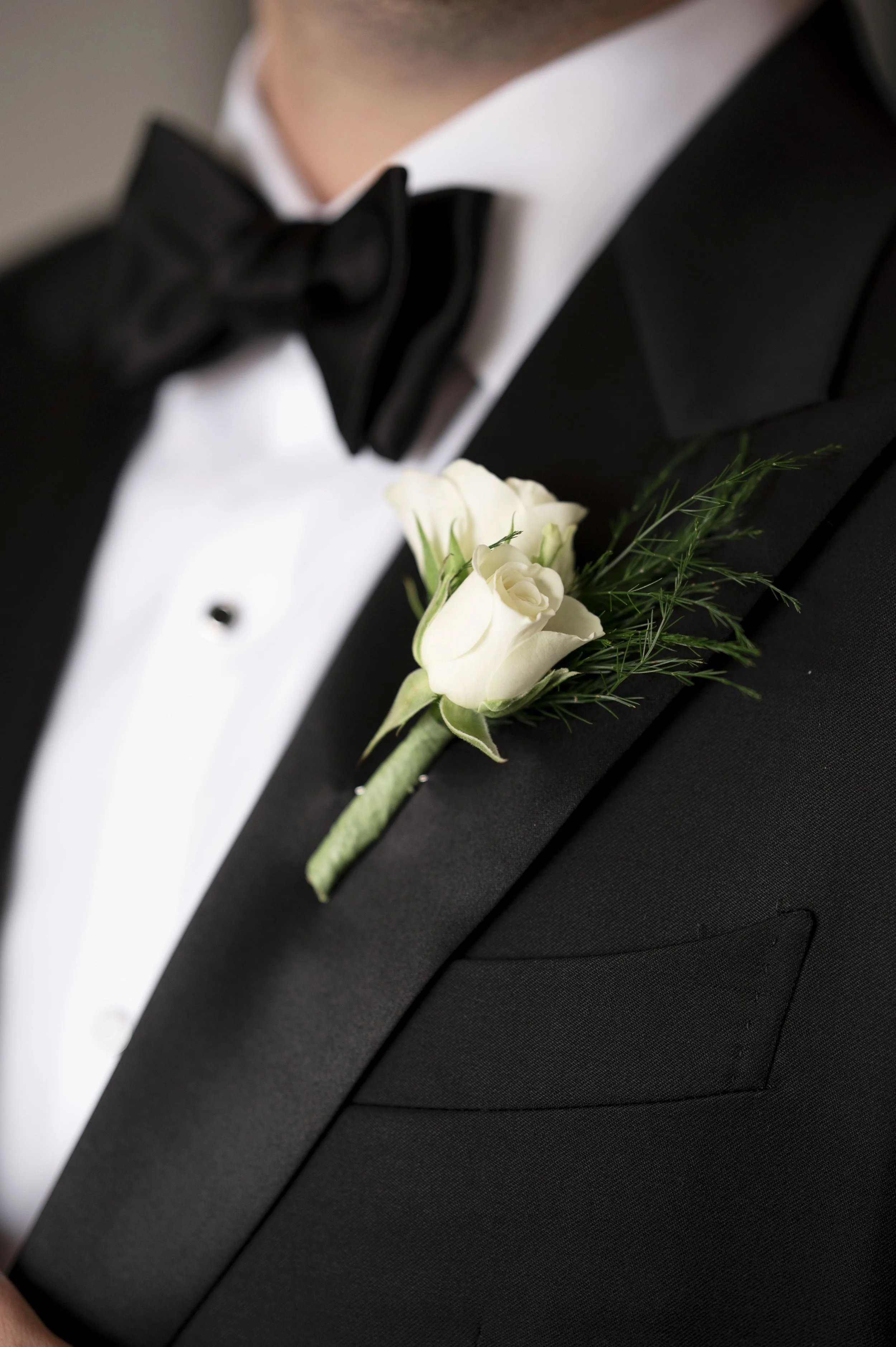 close up details of a boutonniere on grooms jacket