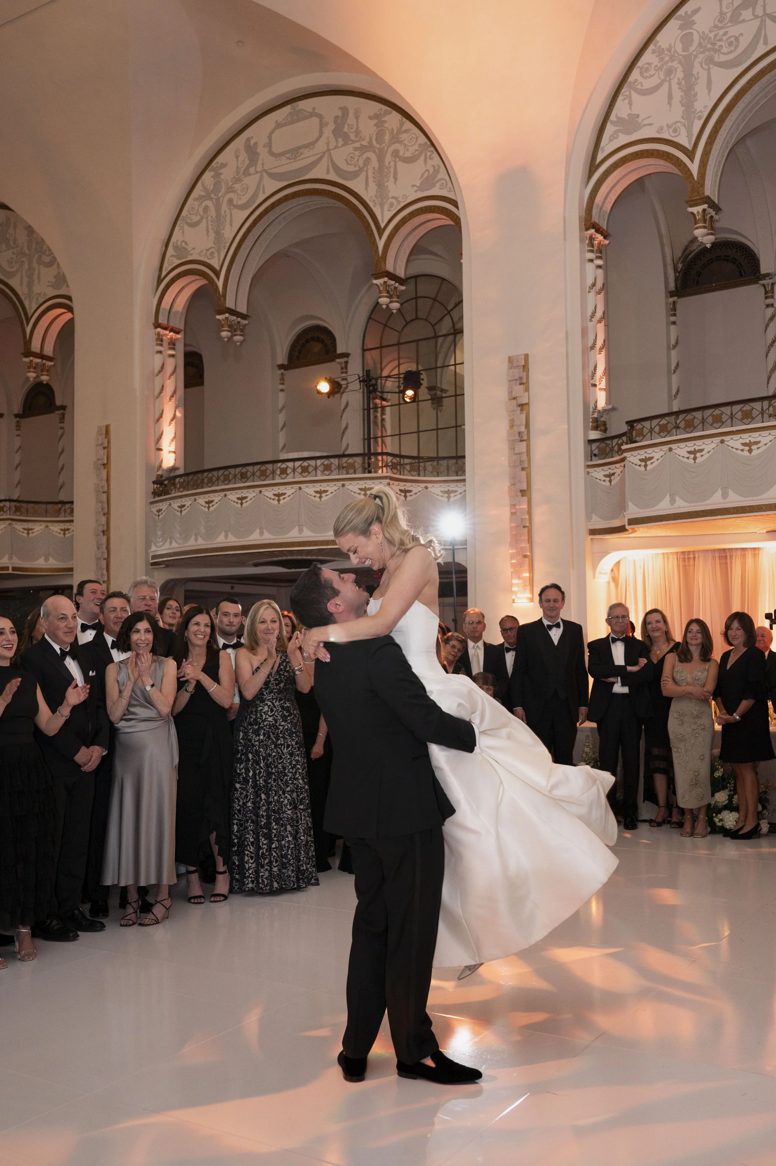 groom lifts bride on the hair as they dance their firs dance in the diddle of the dance floor at the park plaza hote