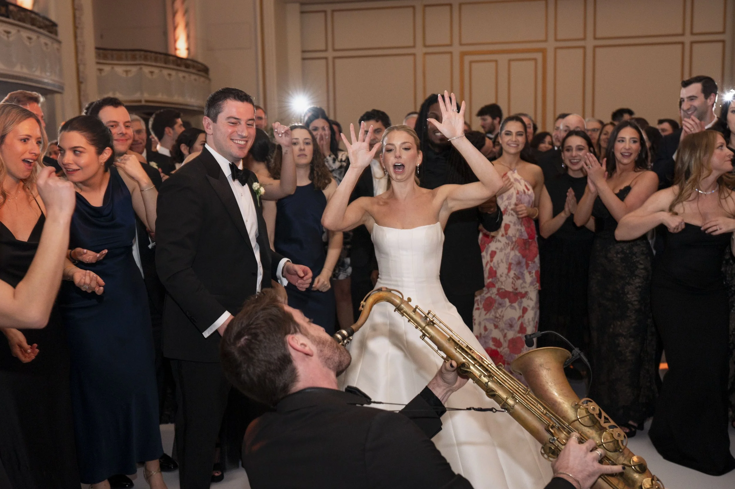 bride and groom dancing with guests in the diddle of the dance floor