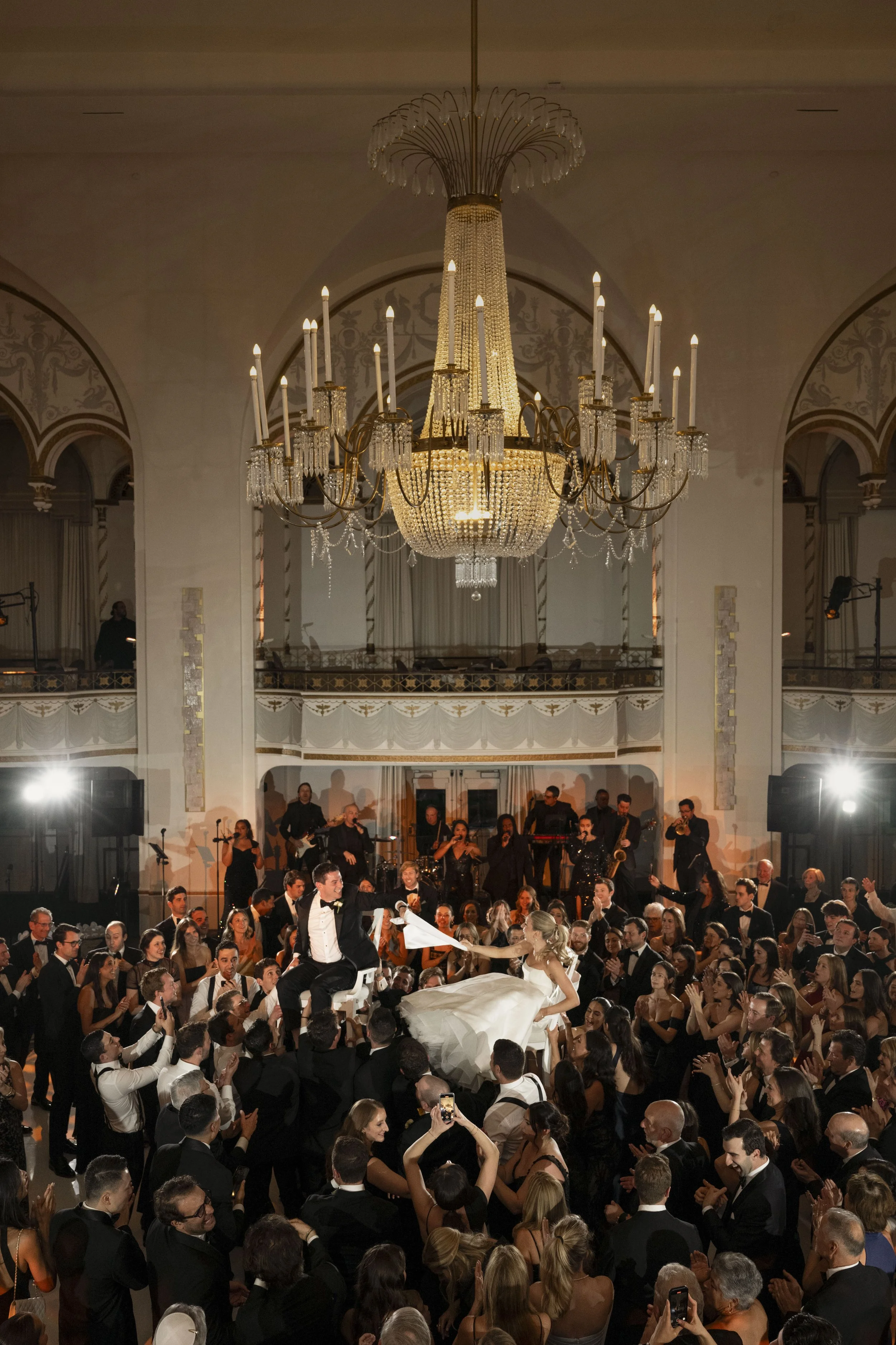bride and groom lifted on chairs in the middle of the dance floor on their wedding day