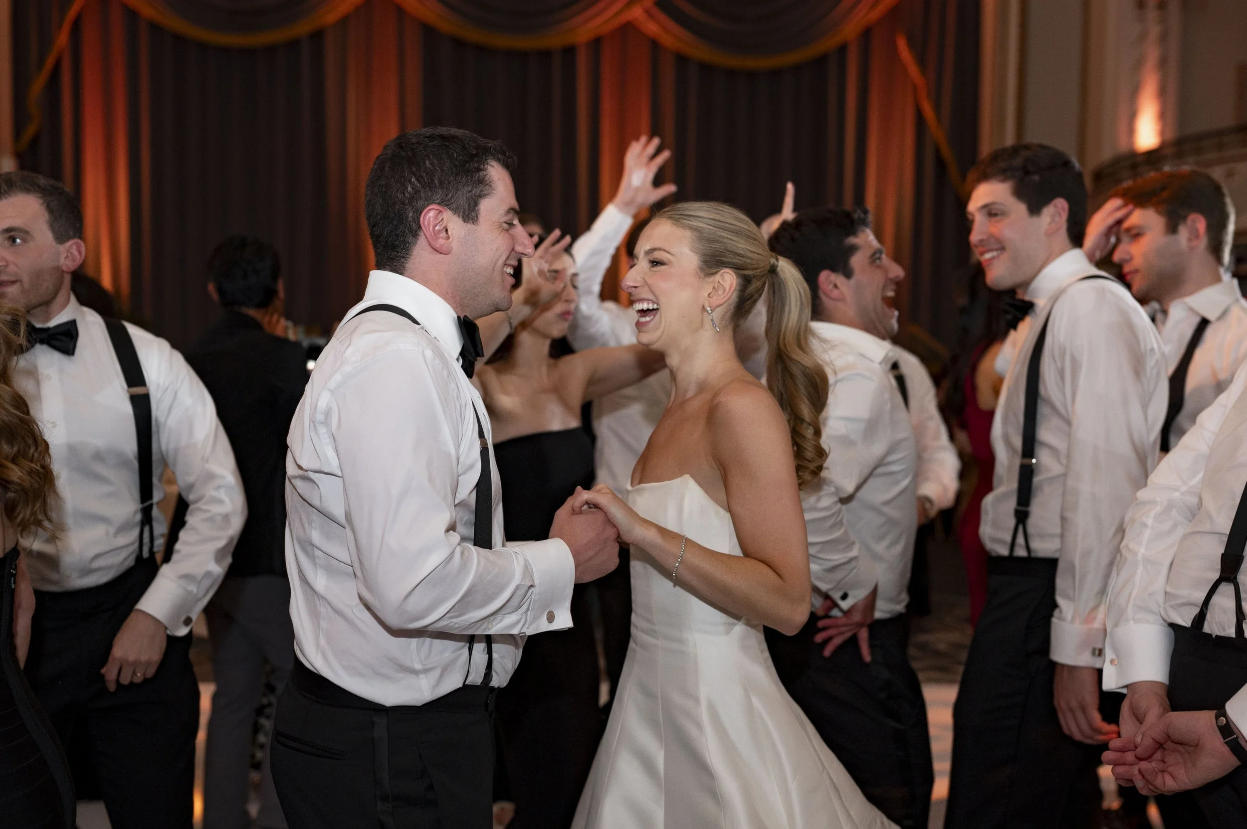 bride and groom dancing surrounding by all guest in the dance floor