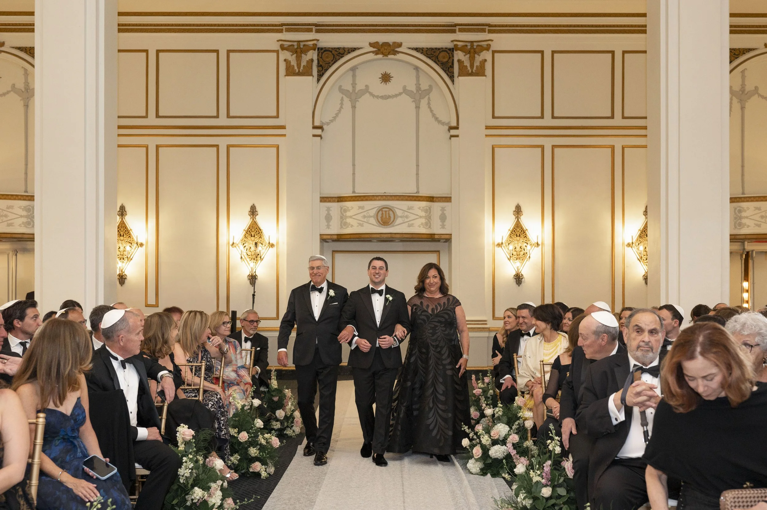 groom walking down the isle with father and mother for a jewish wedding at the park plaza 
