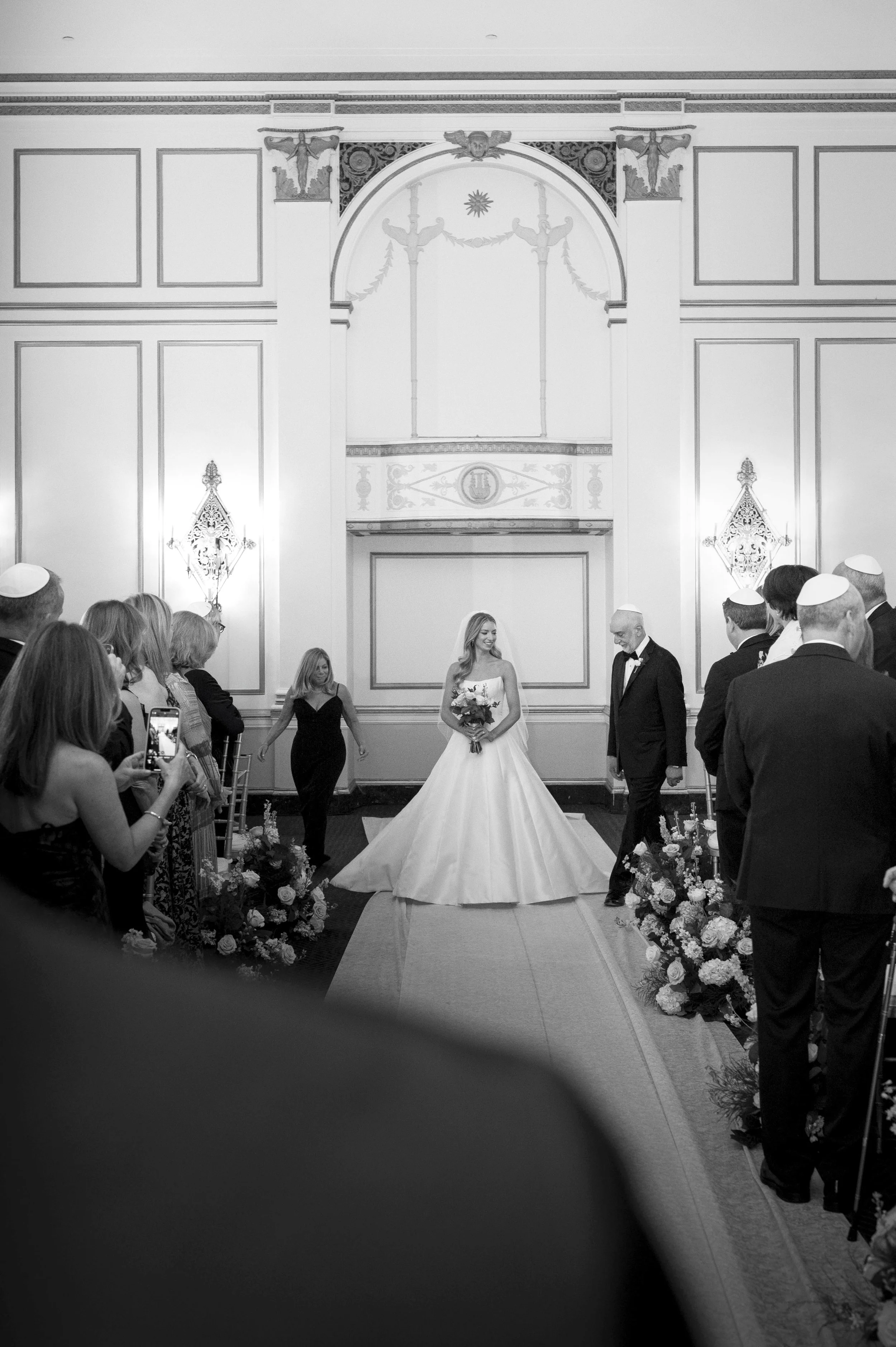 bride walking down the isle during her jewish wedding at the boston park plaza