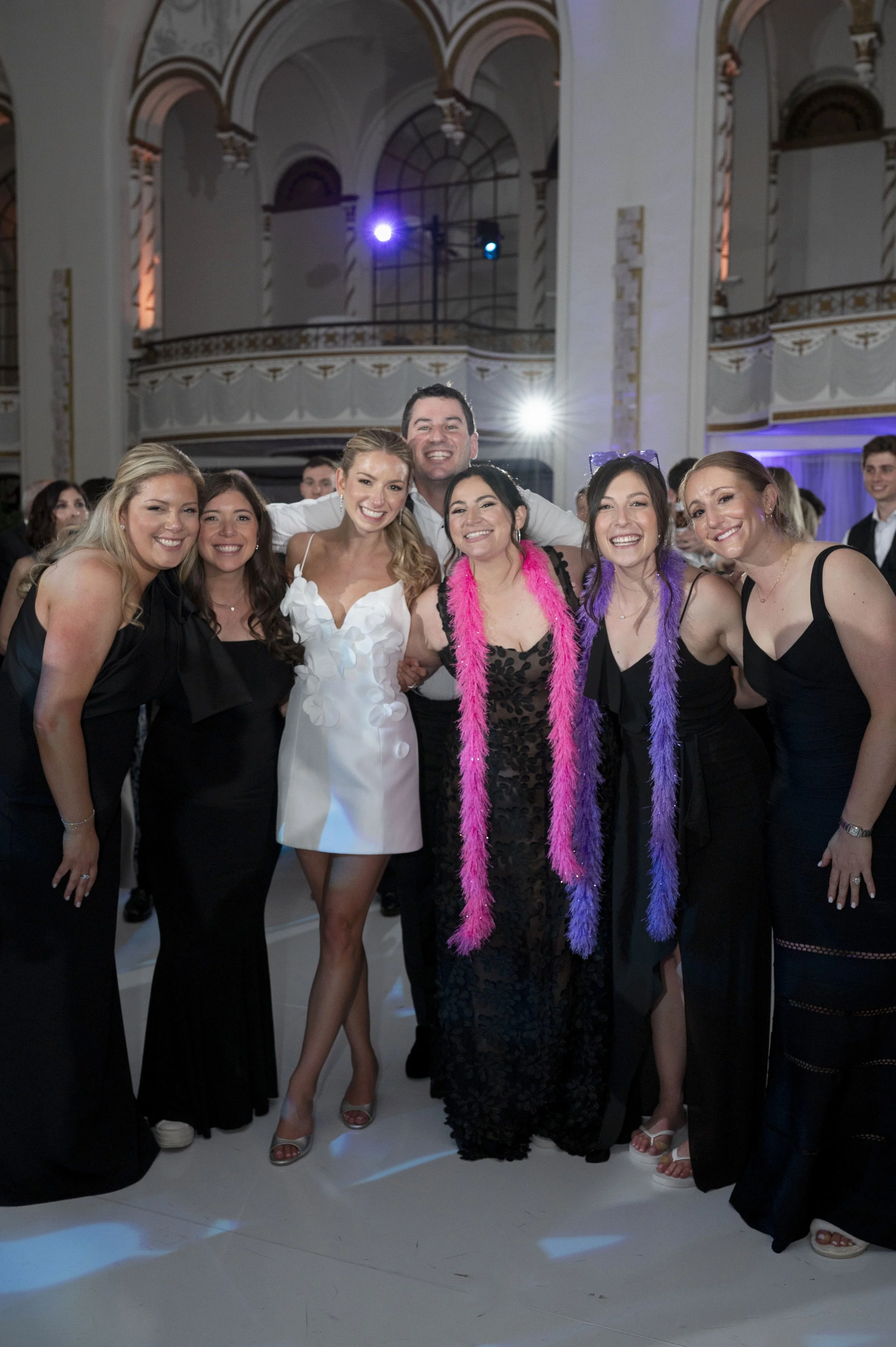 bride and groom posing with friends in the reception 