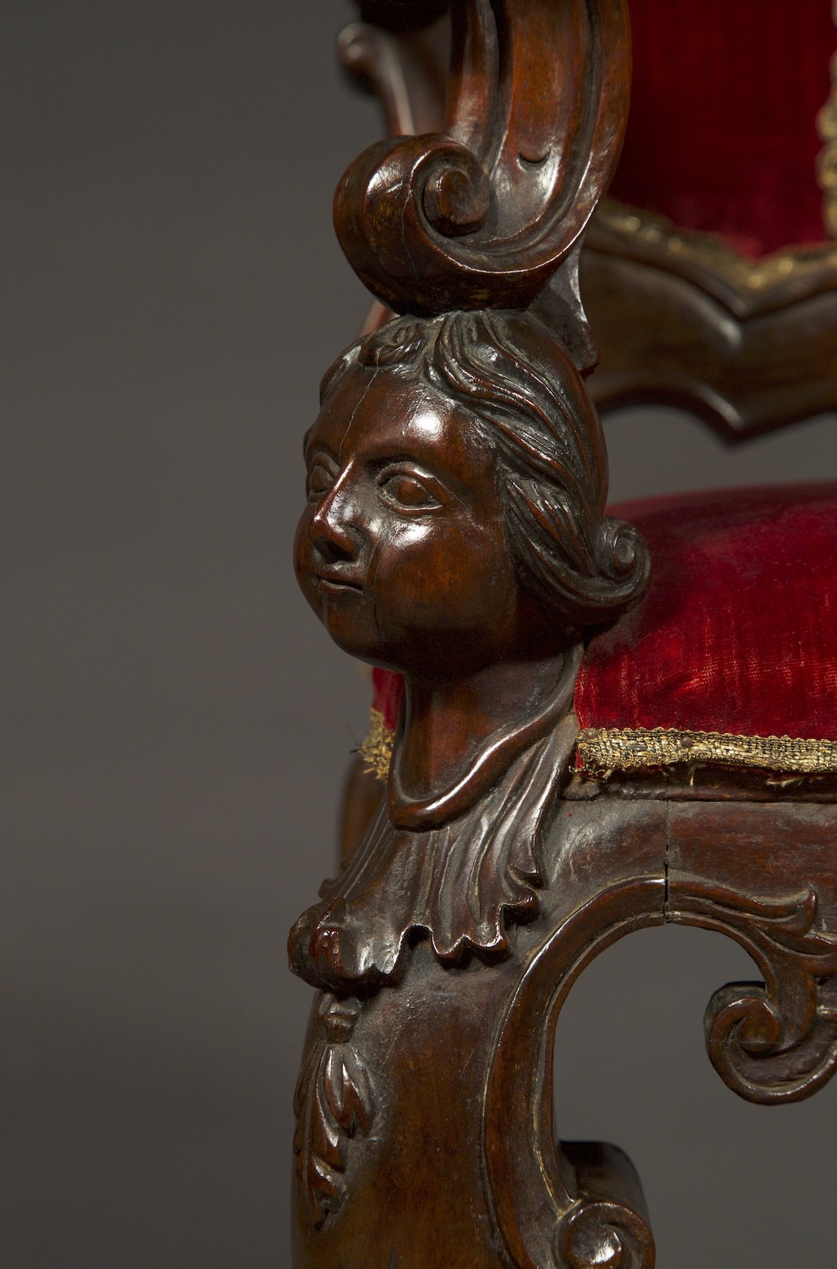 Quarter view of the cherubic bust decoration of the chair