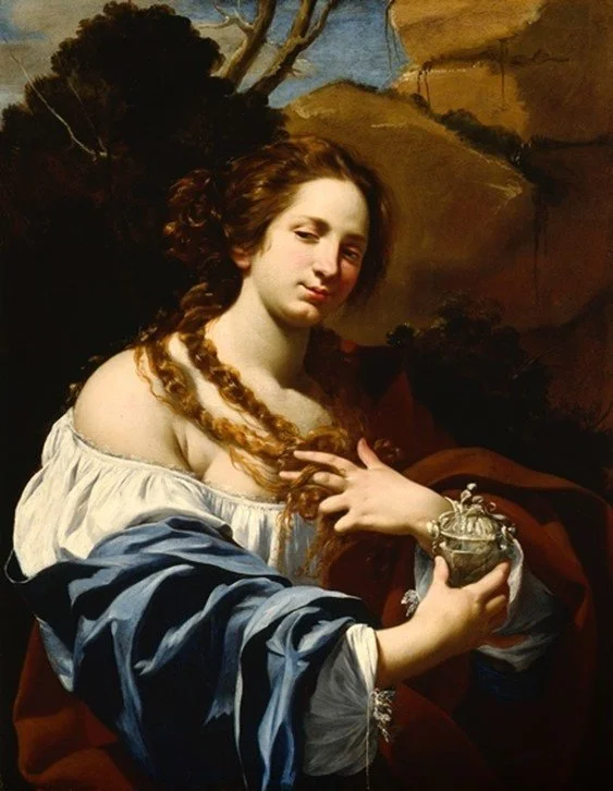 Young woman holds a jar in her right hand and touches her hair with her left hand against a natural background.
