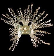 Gold Incan sun mask with radiating zigzag rays on dark background