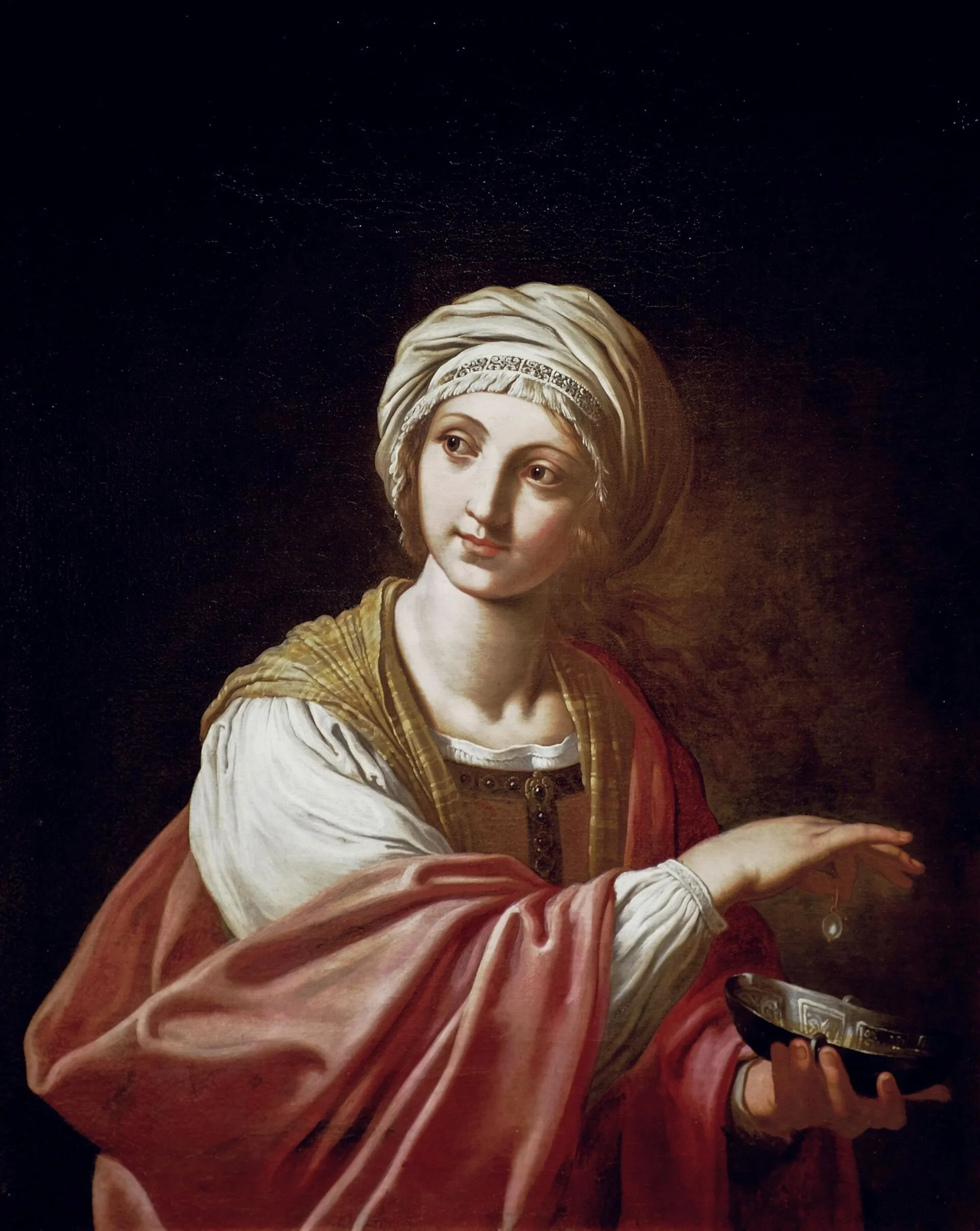 A woman in eastern dress and turbanned looks to her right as she drops a pearl into a vessel.