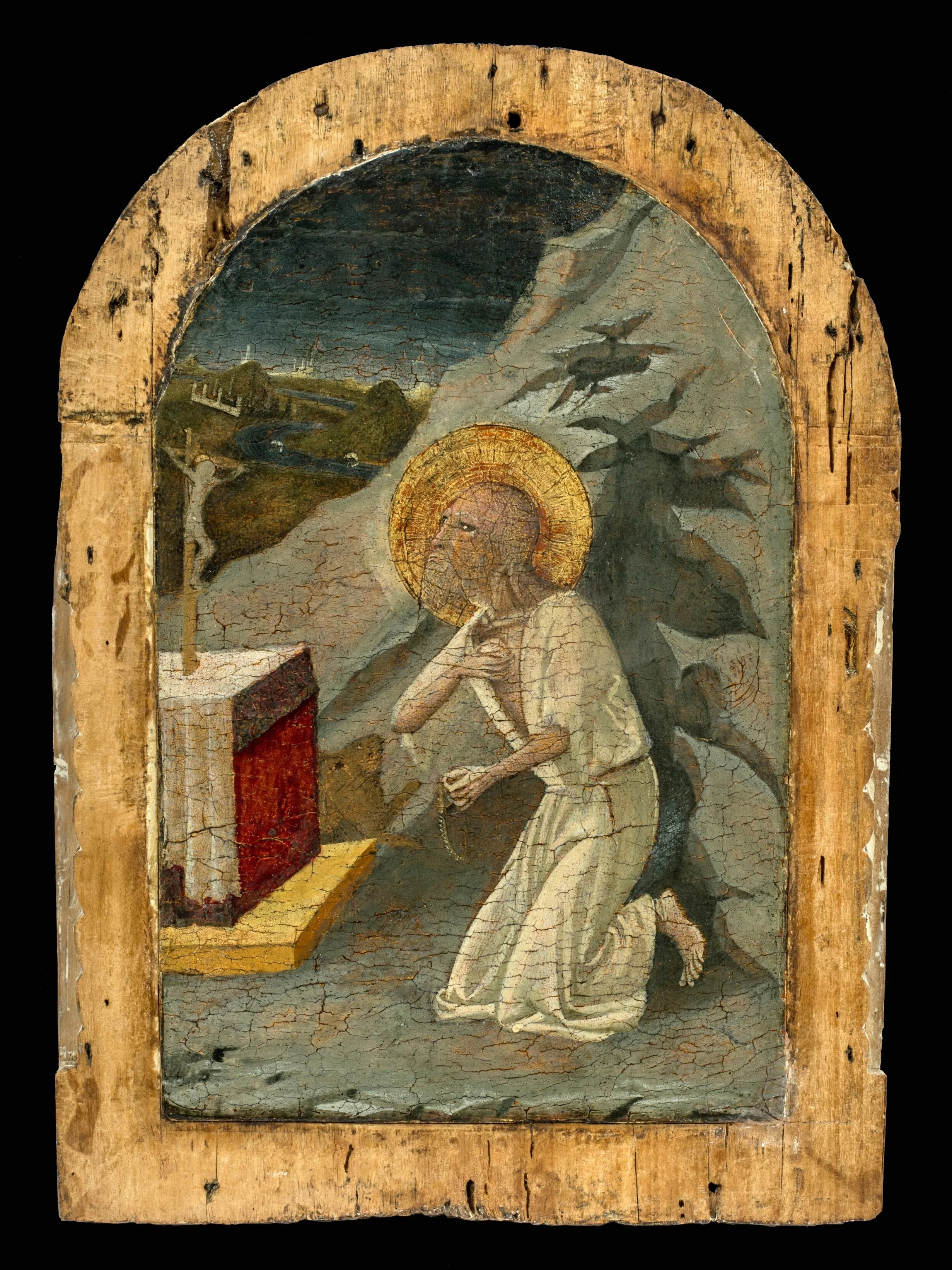 a man in a rocky landscape kneeling before an altar