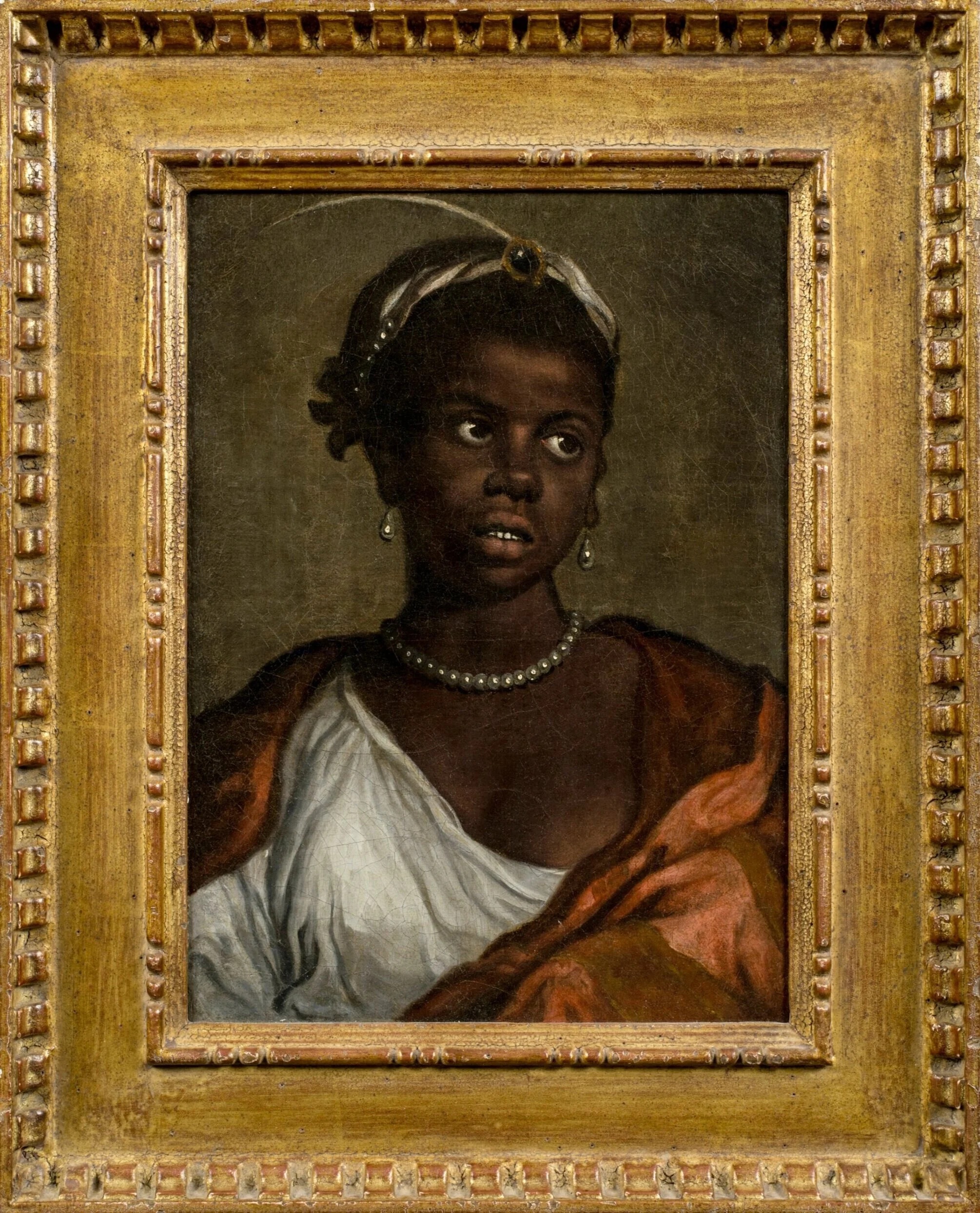 A woman in a white toga looking to her left. A diadem with a plume and a gemstone adorn her hair.