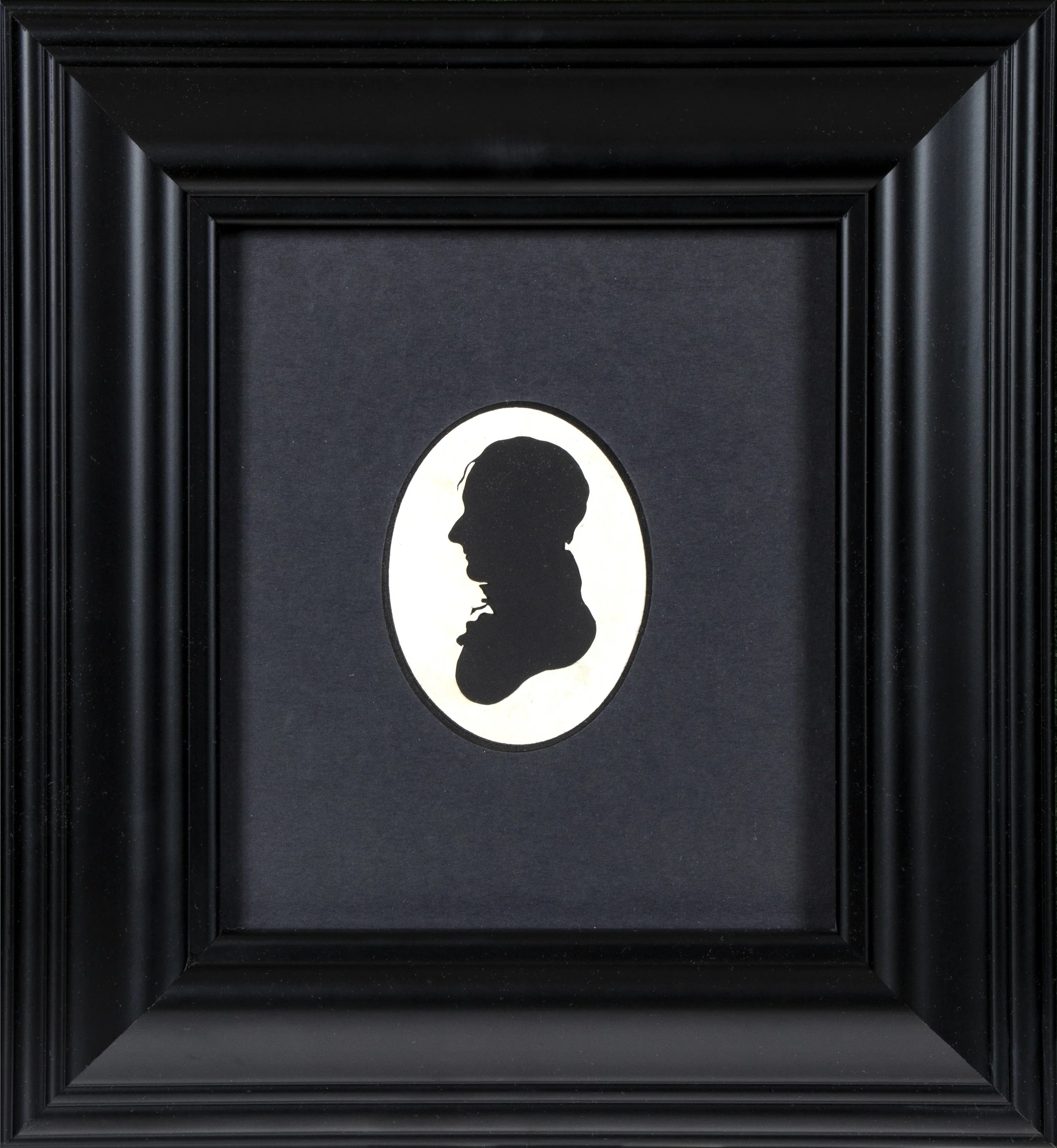 Bust of man in profile looking to the left in oval frame