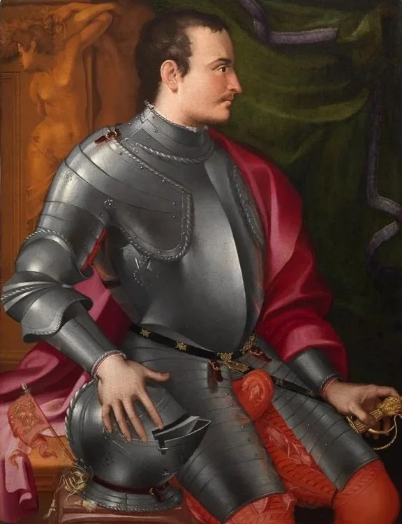 Armored man in profile wearing a red clock and resting on hand on helmet