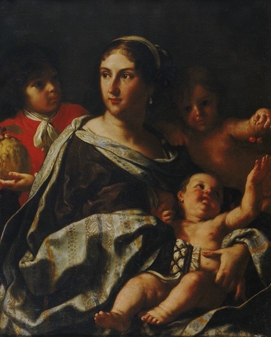 Woman holding a naked baby while two children behind her holding fruit