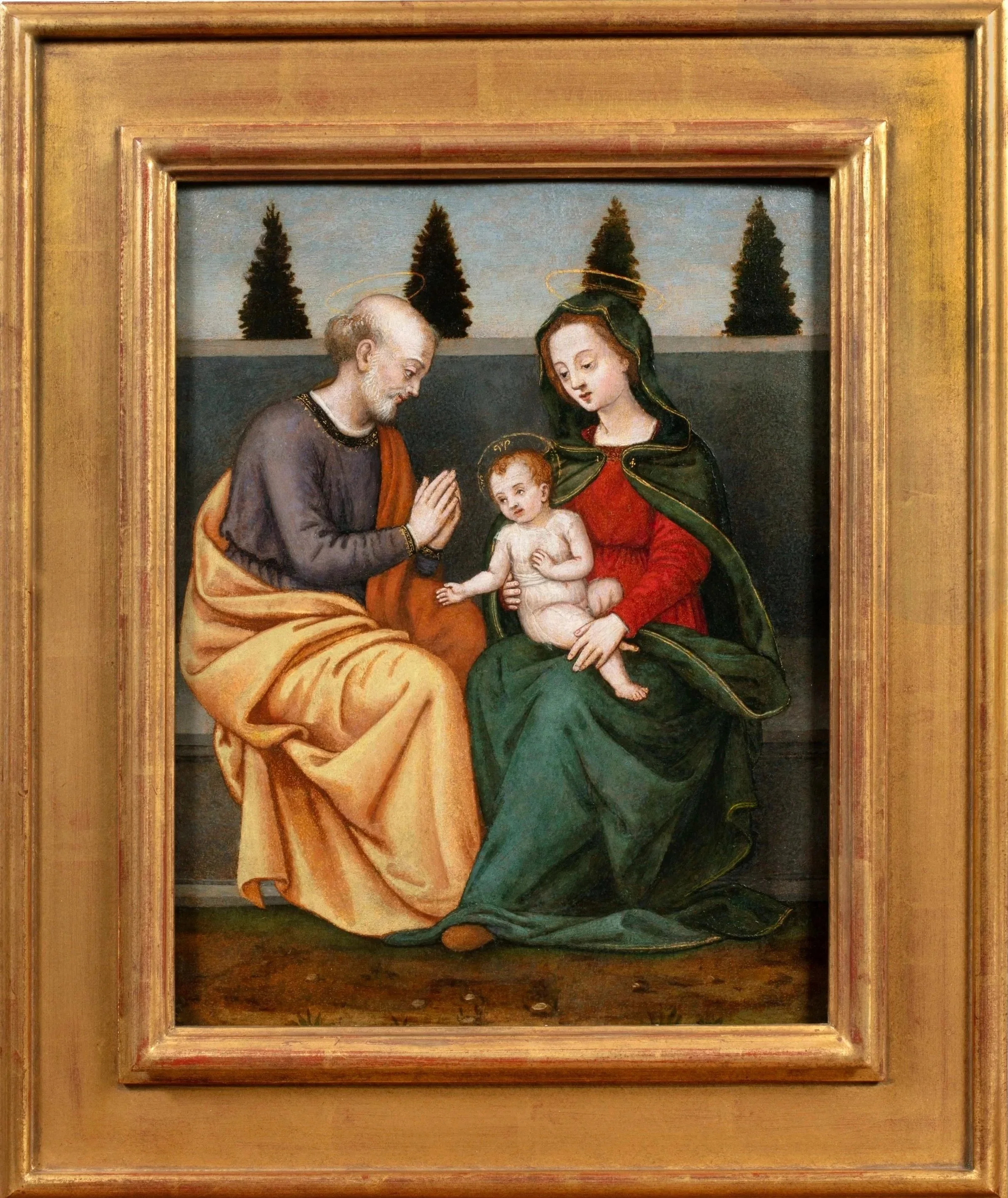 Virgin Mary holds infant Christ beside praying Saint Joseph seated before a low wall and cypress trees