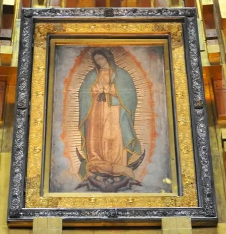 Framed image of the Virgin of Guadalupe displayed in basilica with ornate gold and dark border