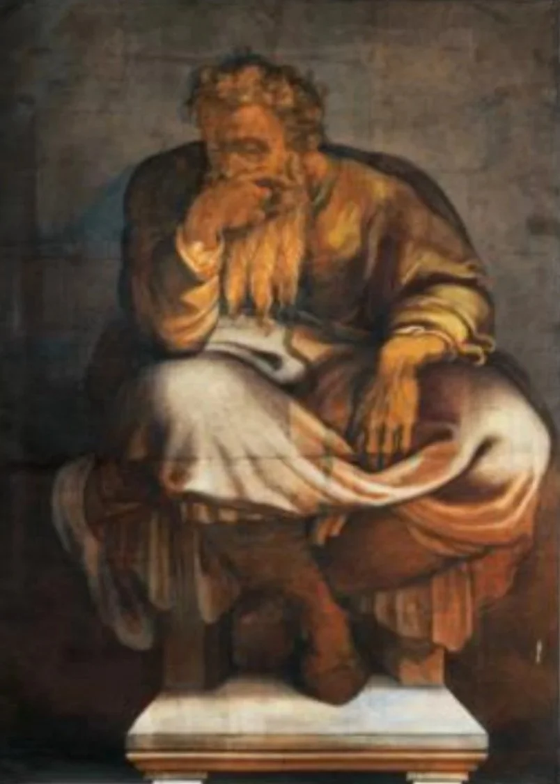 Bearded man seated holds hand on mouth