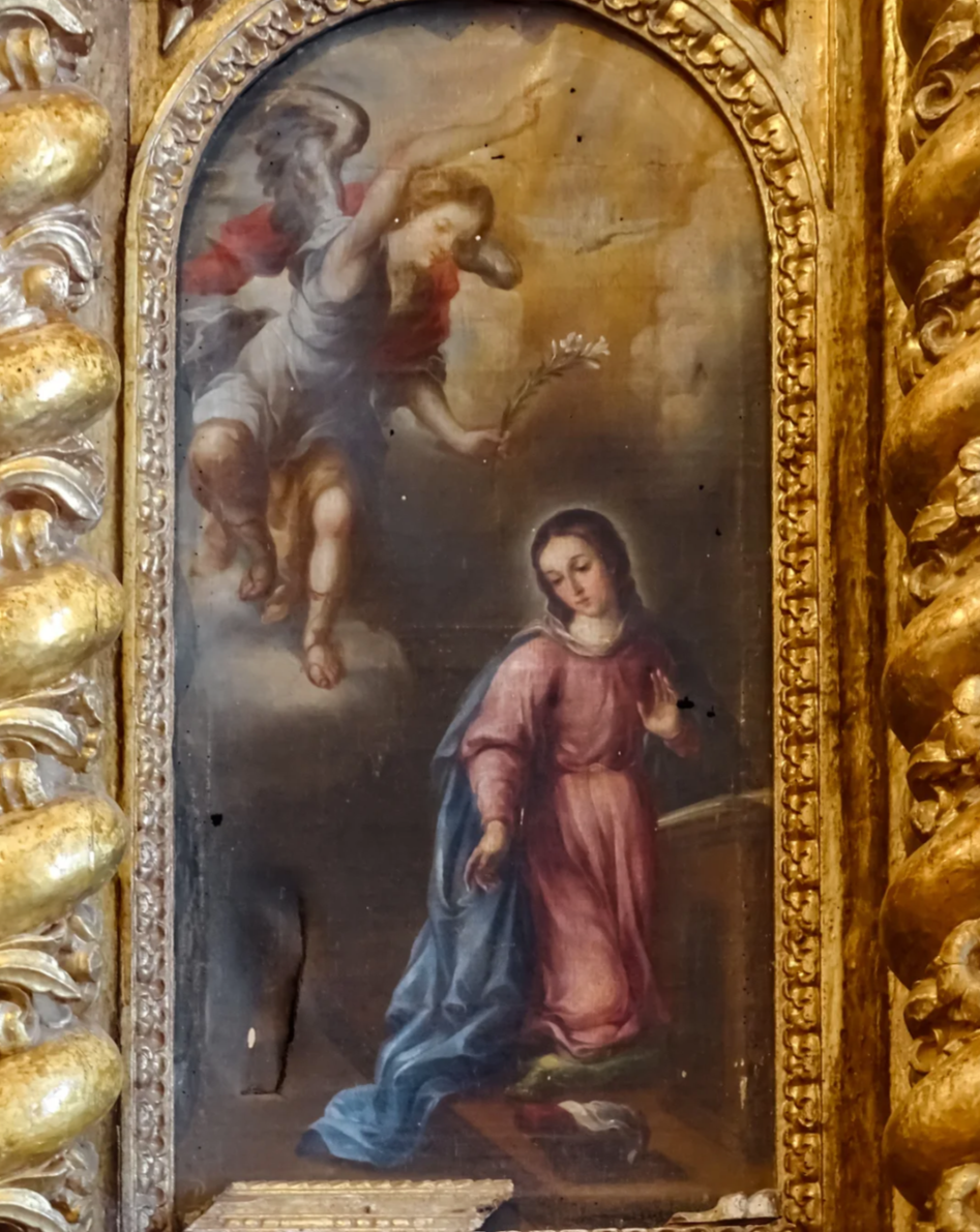 Ornate golden church altarpiece of angel appearing to Mary during Annunciation