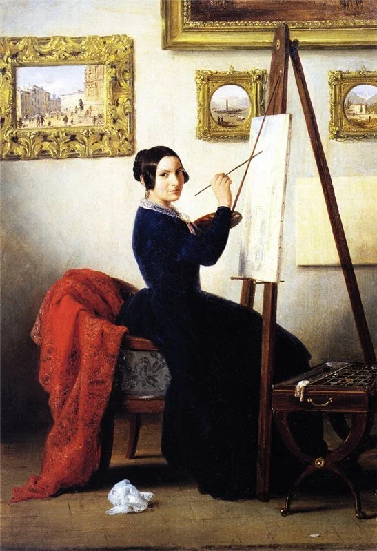 Female painted working at her easel in her studio with several framed view paintings in the background.