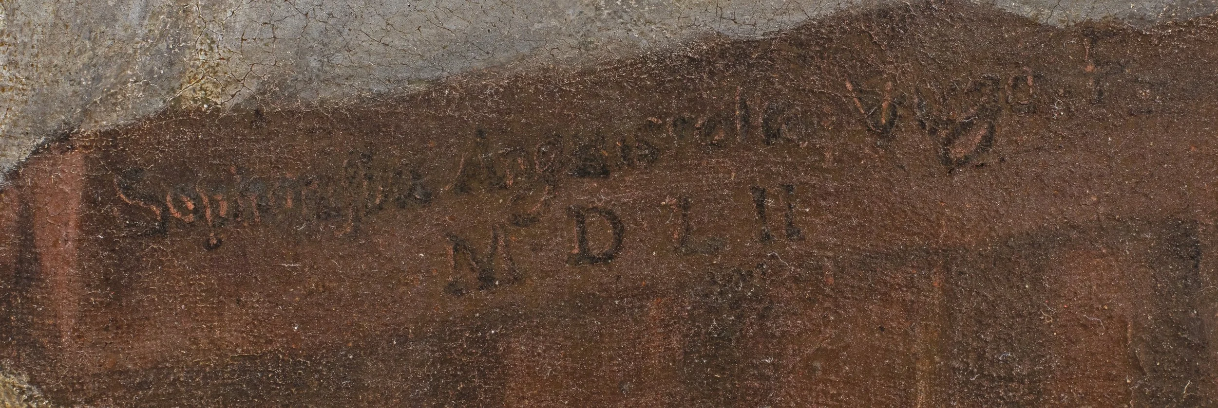 Writing notched into the wood of an chair arm.