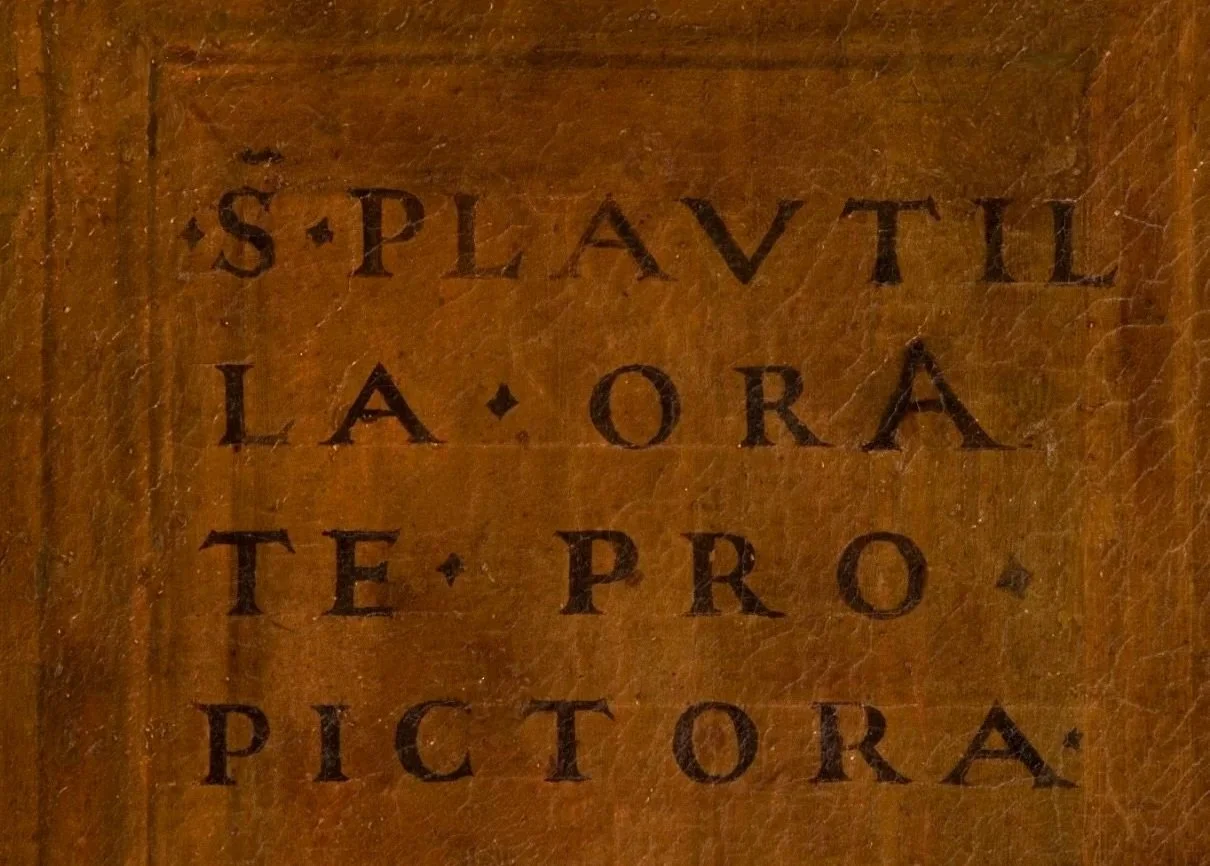 Detail of inscription on a brown painted surface.