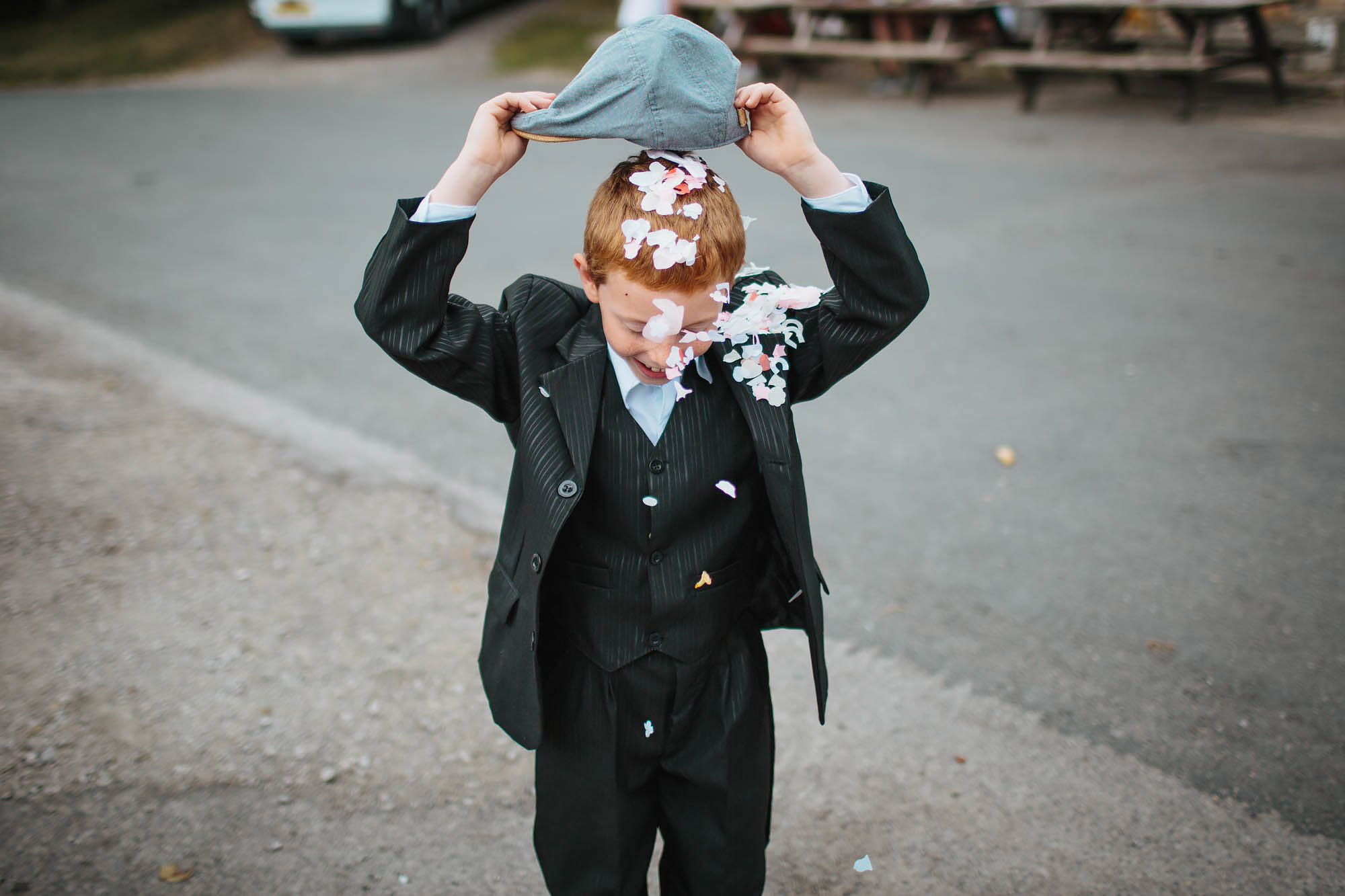 Young boy tips confetti on his head at a Yorkshire wedding