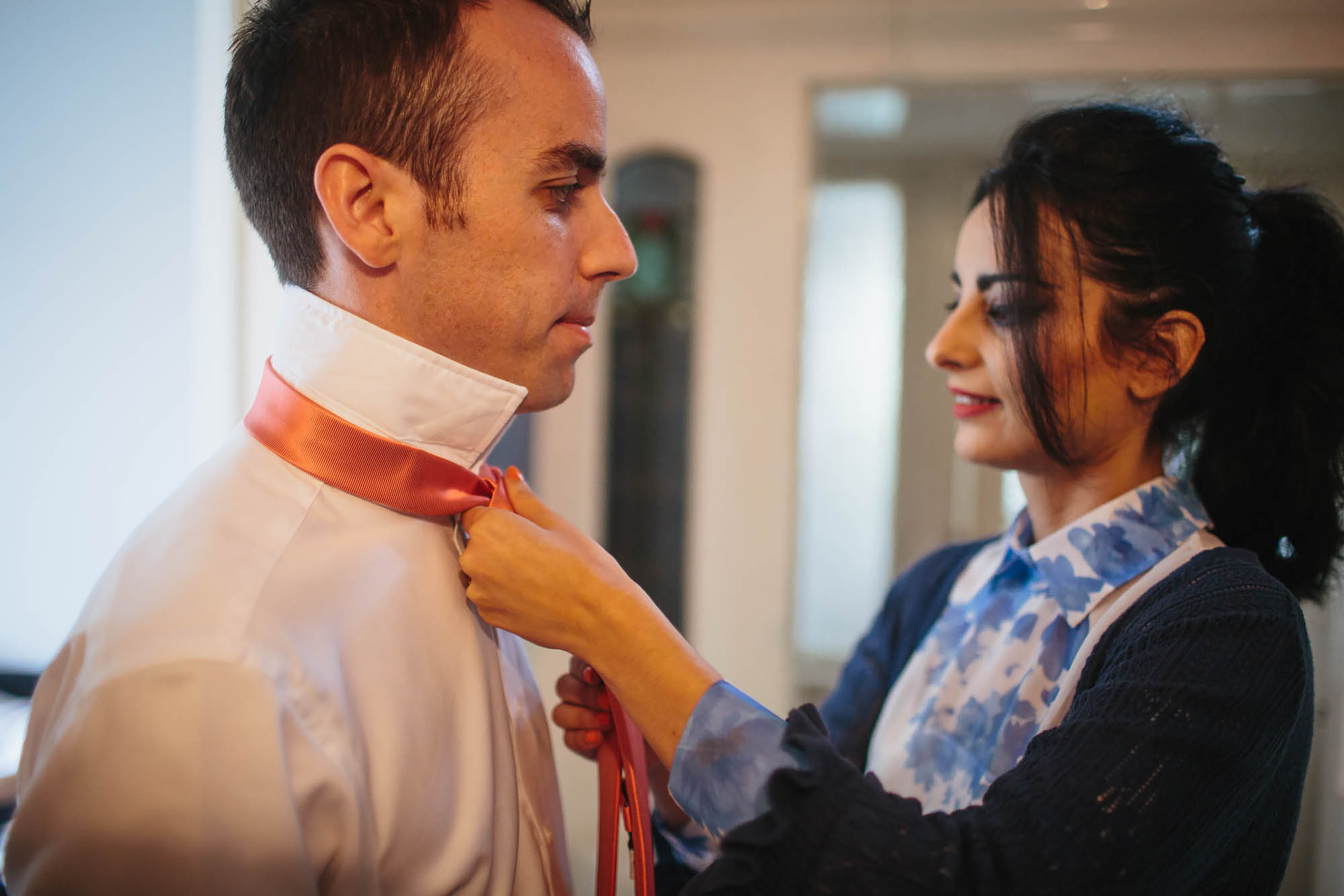 Groom has help with his tie on his wedding day