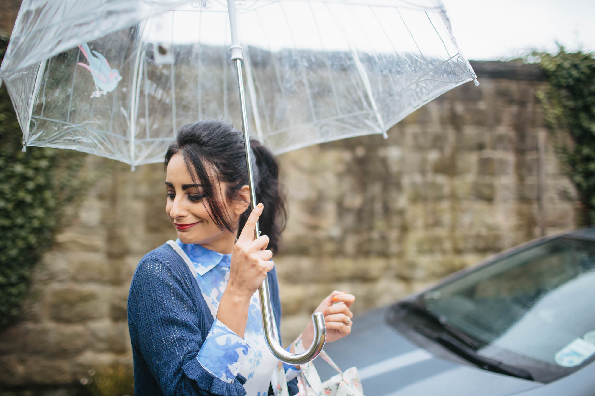 Bridesmaid holding an umbrella on her way to the wedding