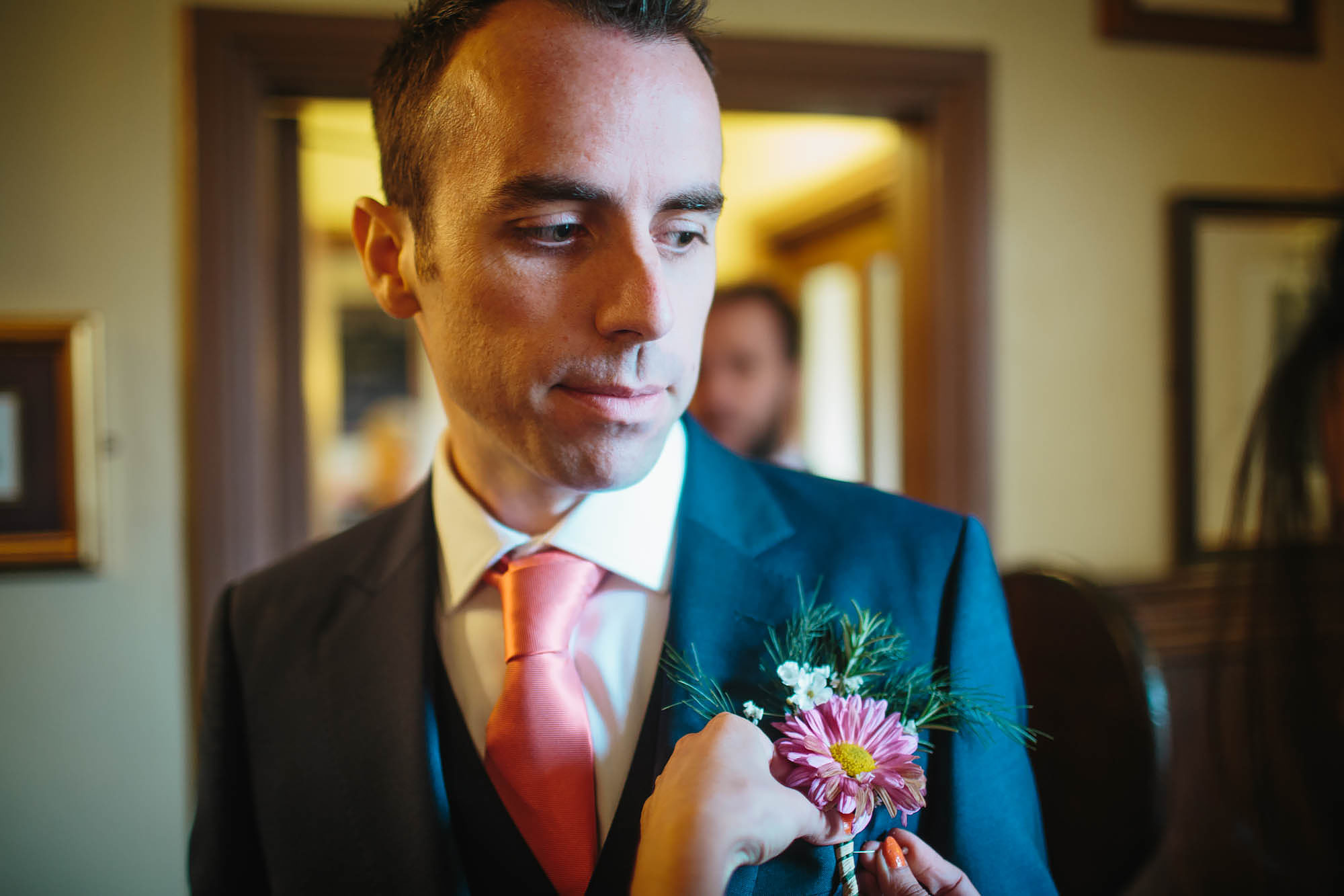 Groom on his wedding day has his buttonhole attached