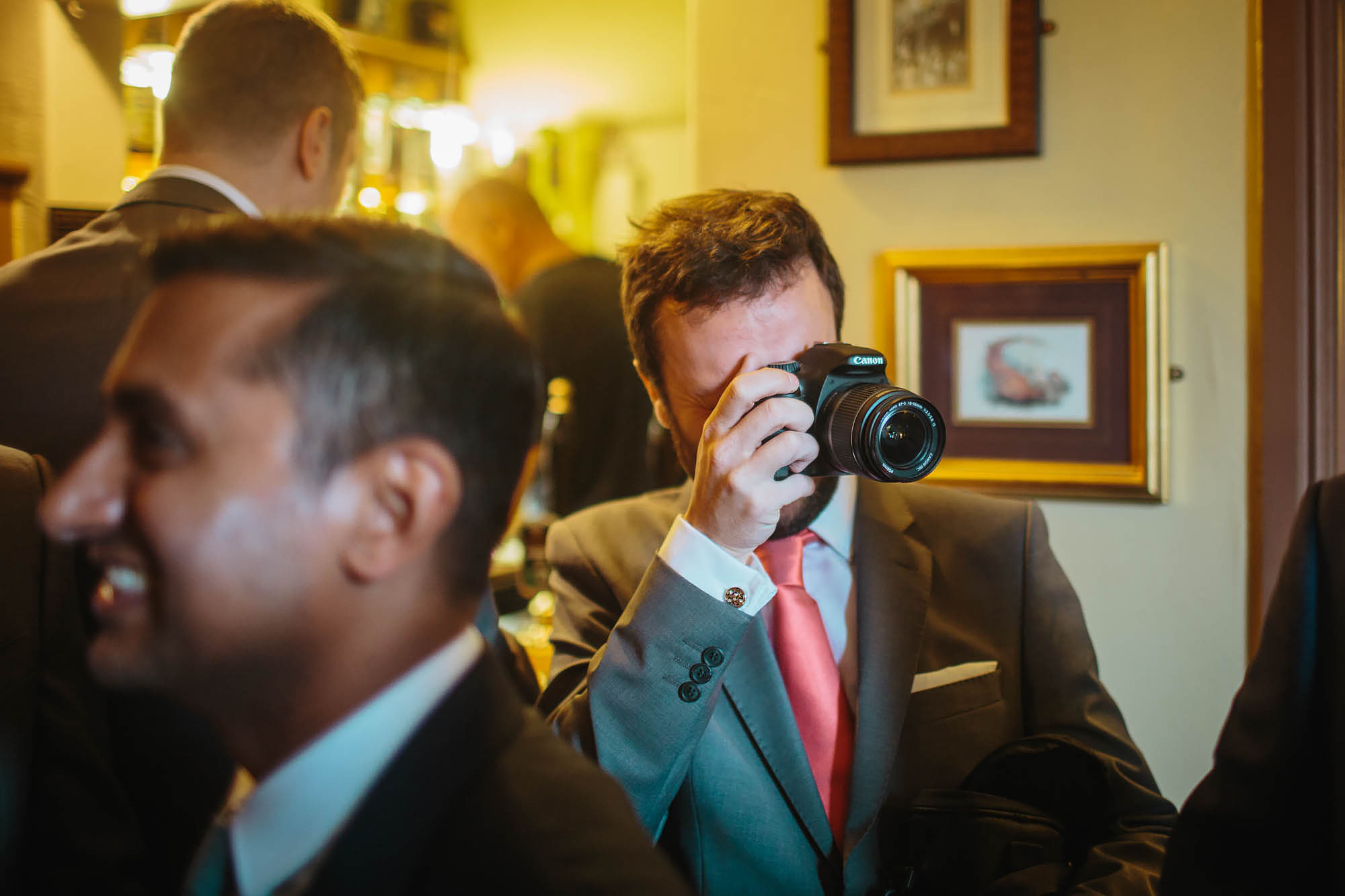 Best man taking photographs with a camera on the wedding day