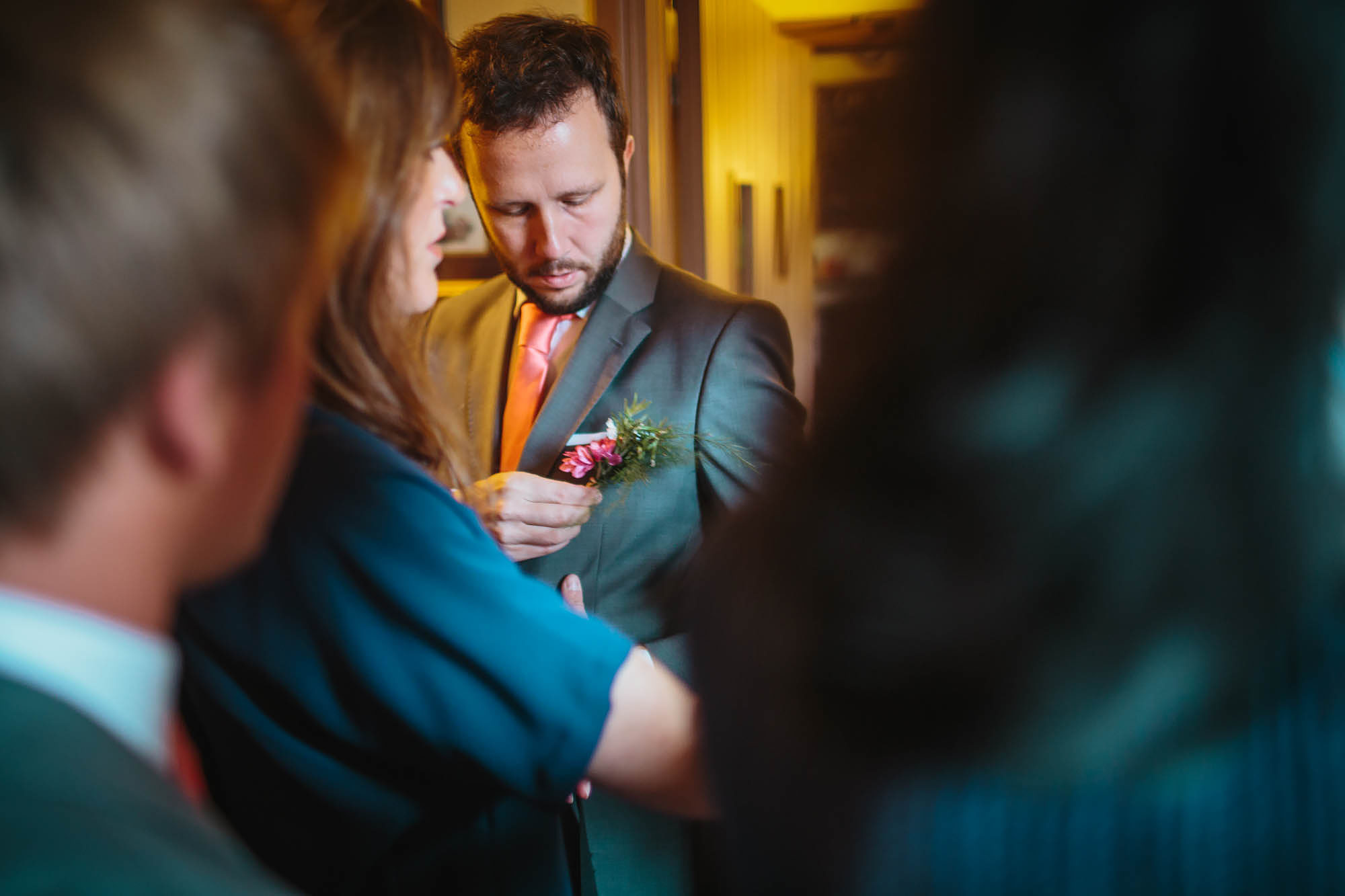 Best man attaches his buttonhole and flower on the wedding day in Yorkshire