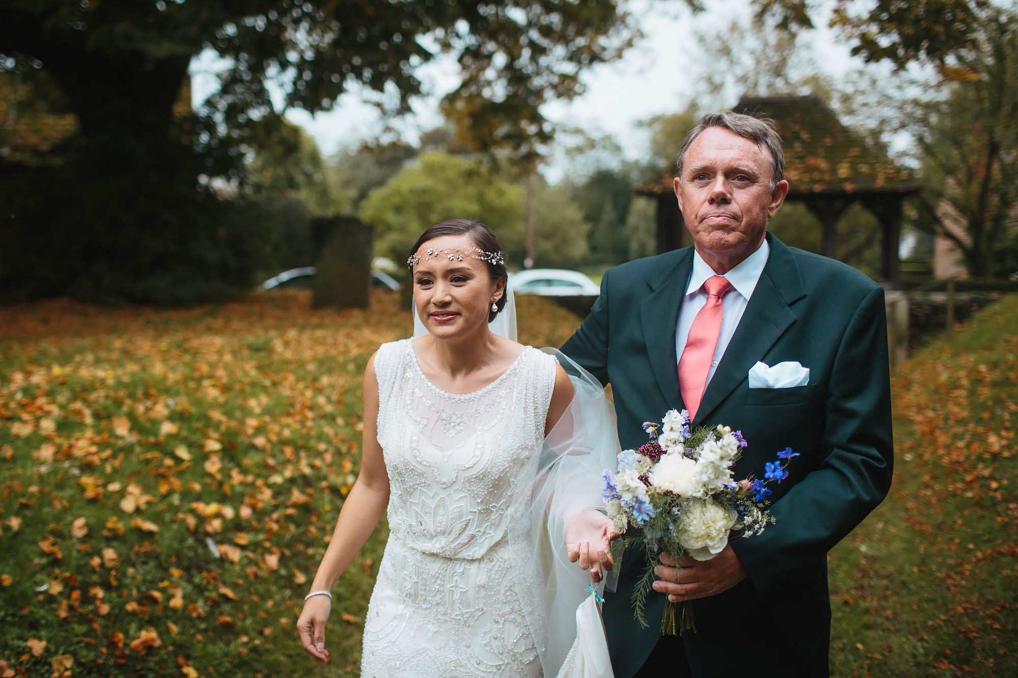 Bride walks to the church with her father on her wedding day