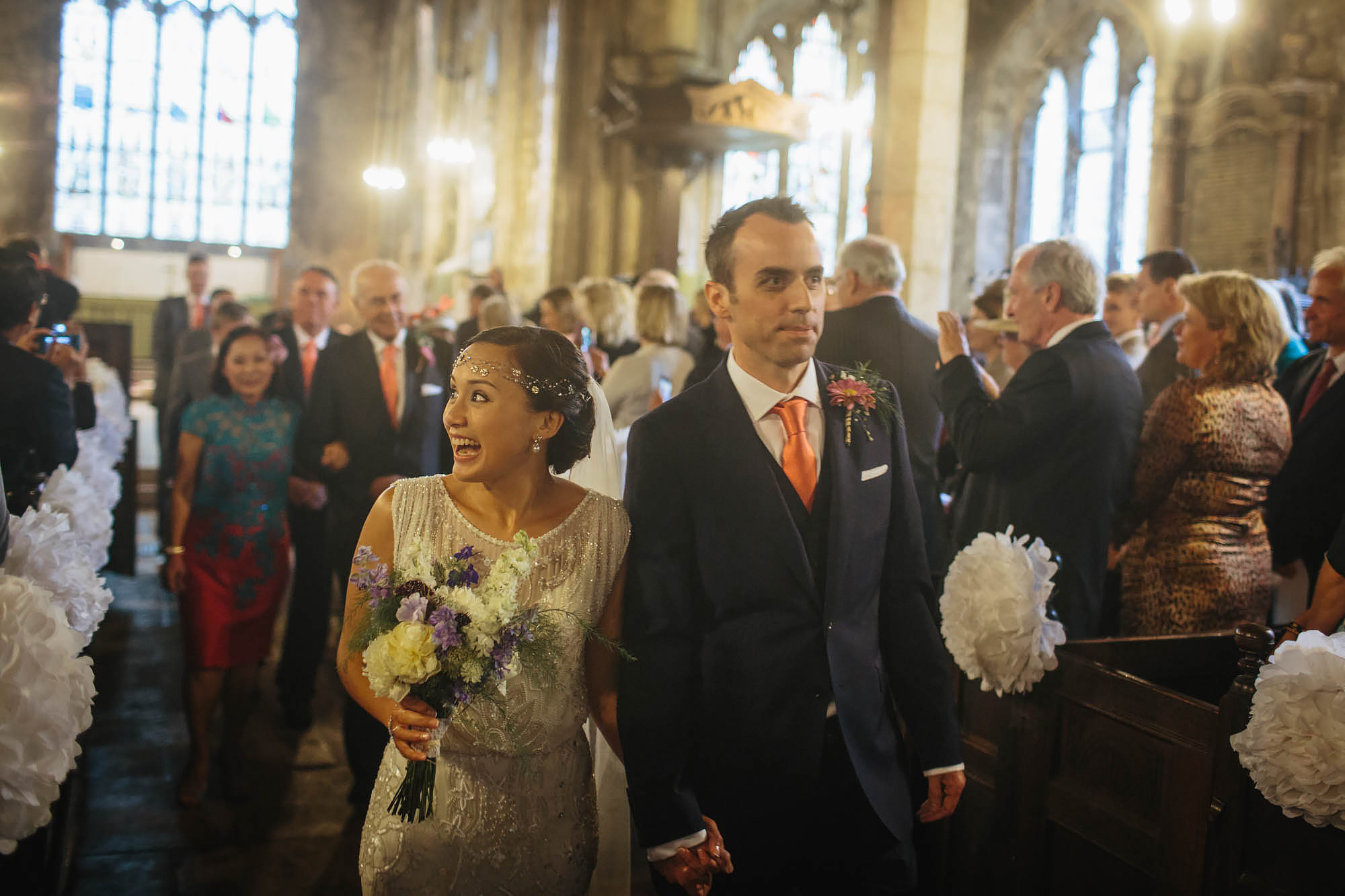 Bride and groom walk down the aisle of a church at their wedding