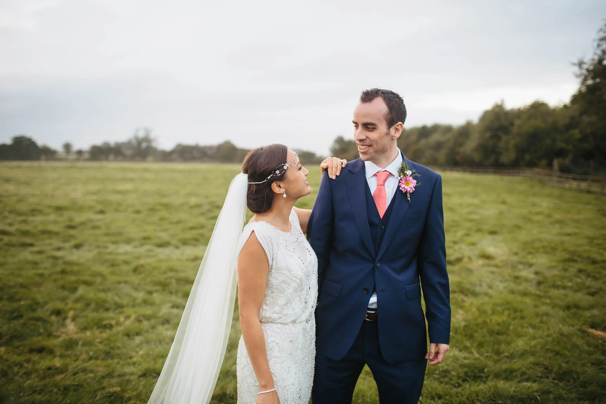 Bride and groom laughing in a field at Hornington Manor