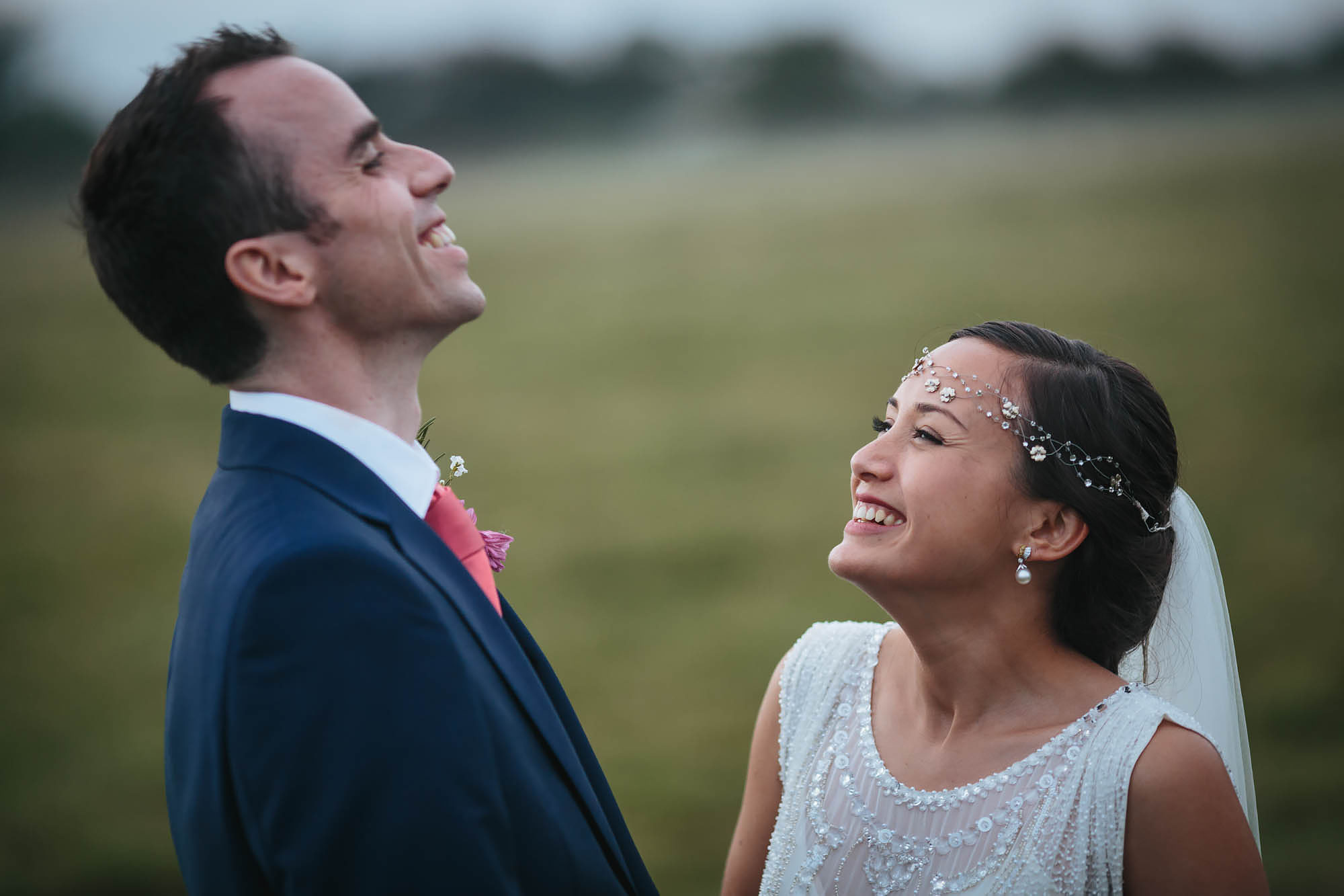 Bride and groom laughing in a field at Hornington Manor
