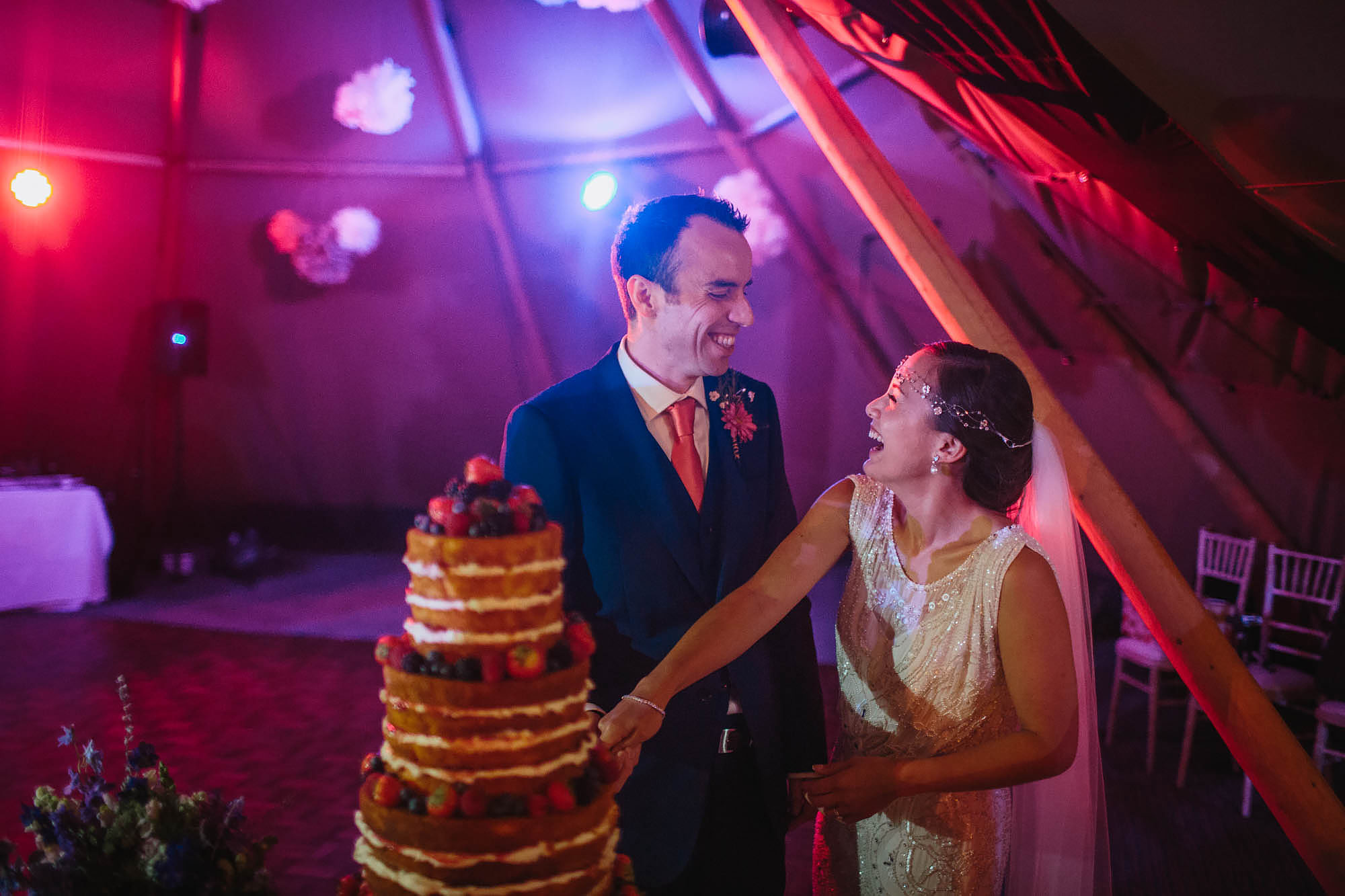 Bride and groom laughing as they cut the cake at Hornington Manor