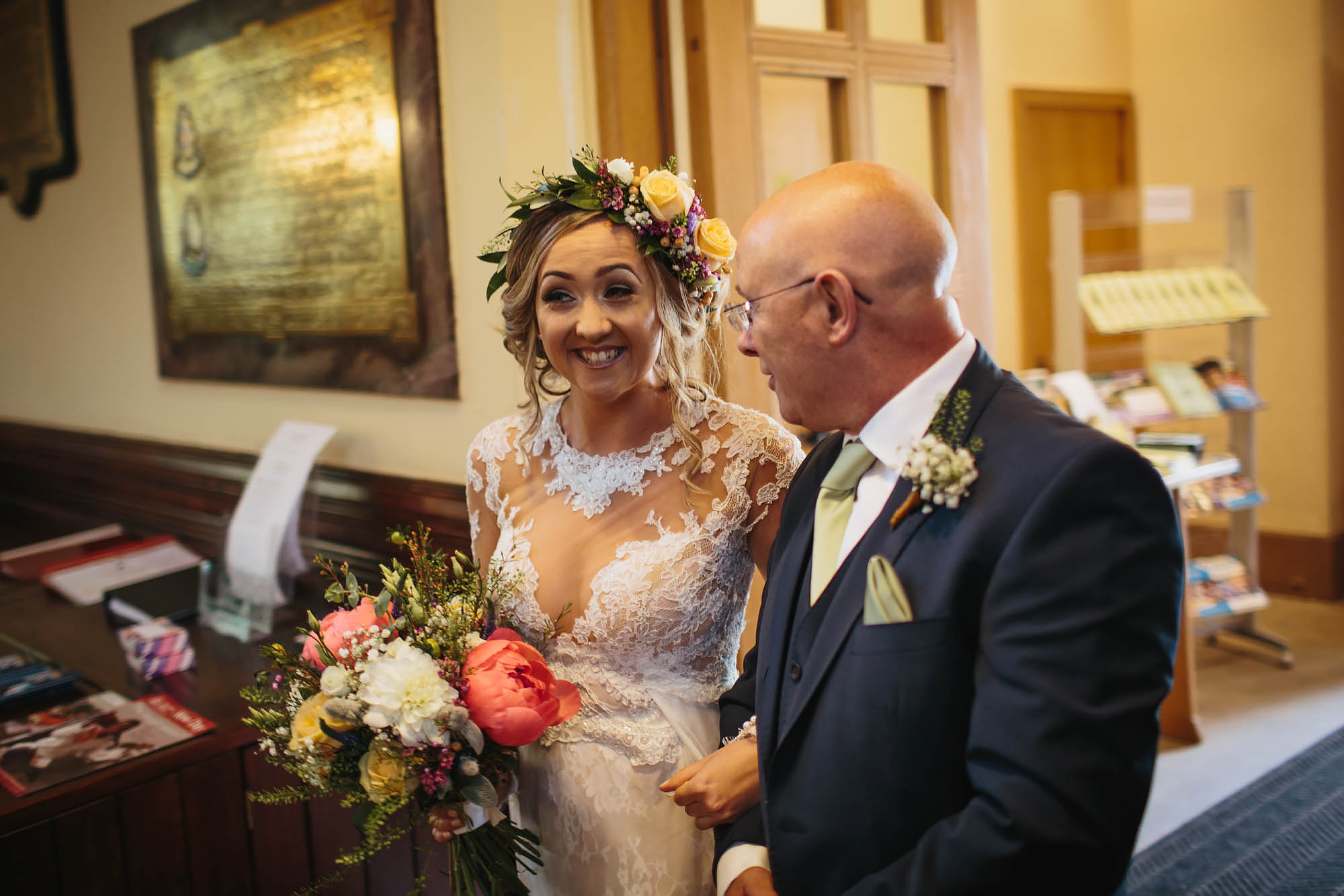 Bride laughing as her father walks her down the aisle at the church