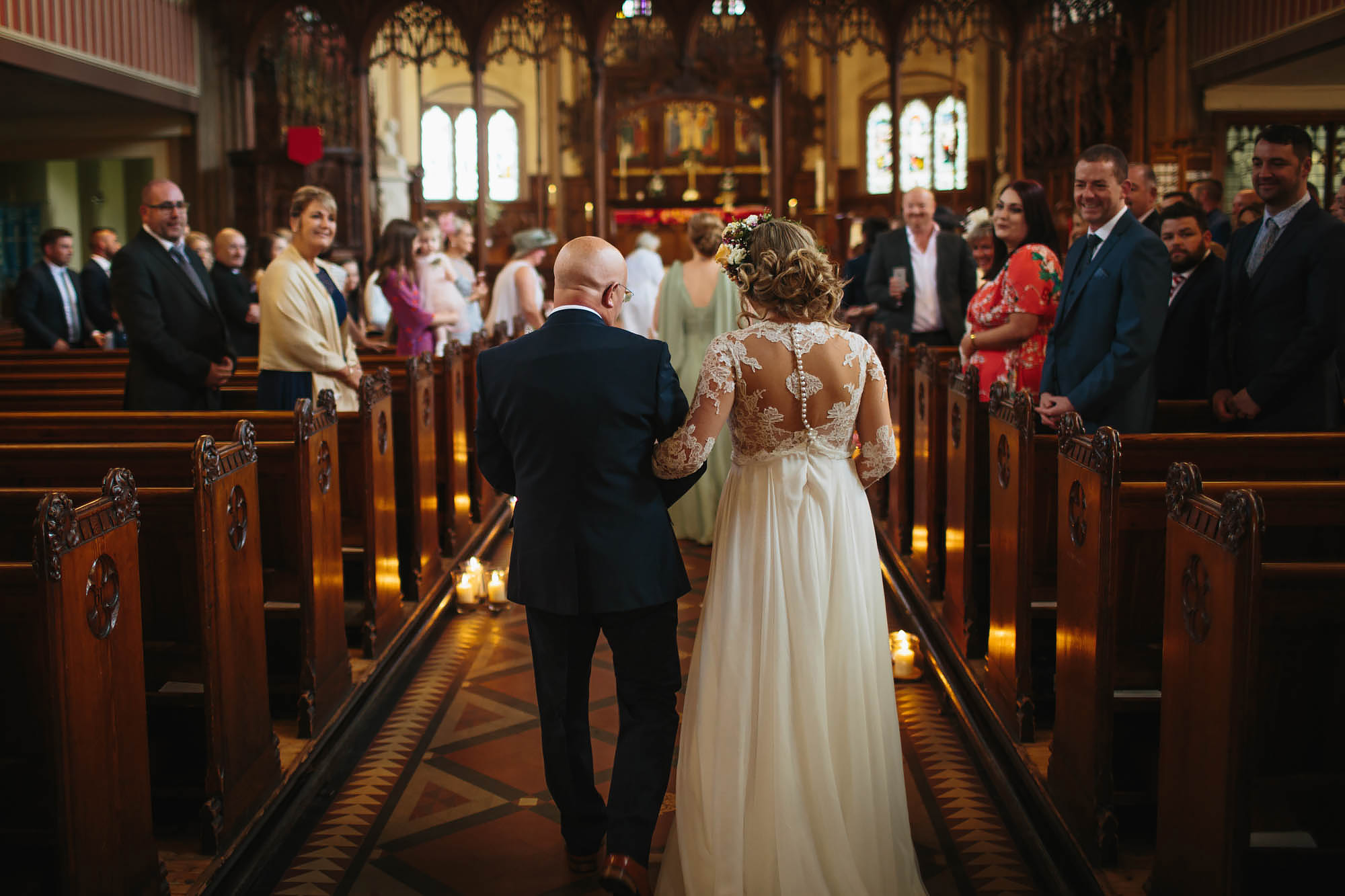 Bride and father walk down the aisle of the church on her wedding day in Manchester