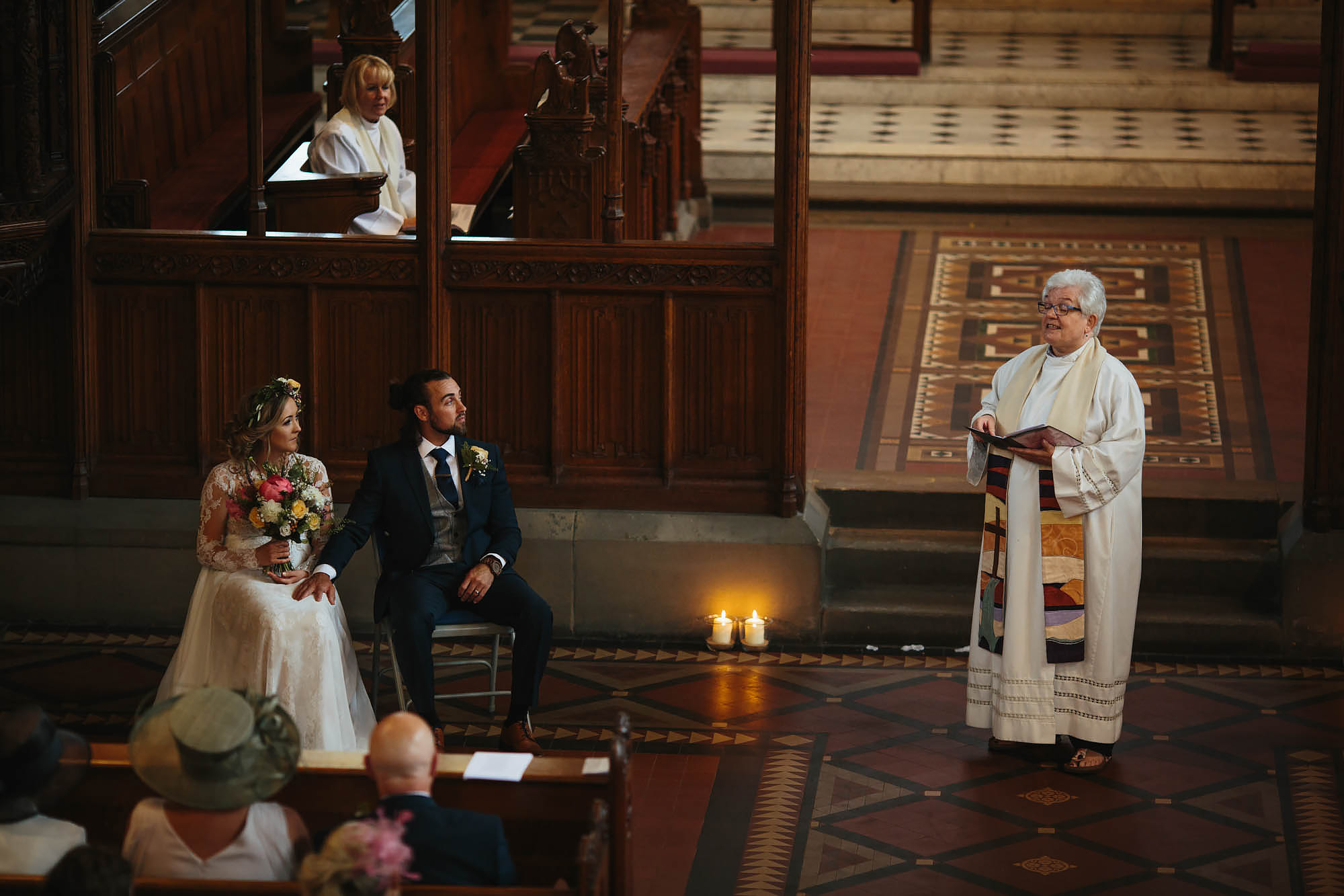 Bride and groom look to the vicar during the wedding ceremony in Manchester