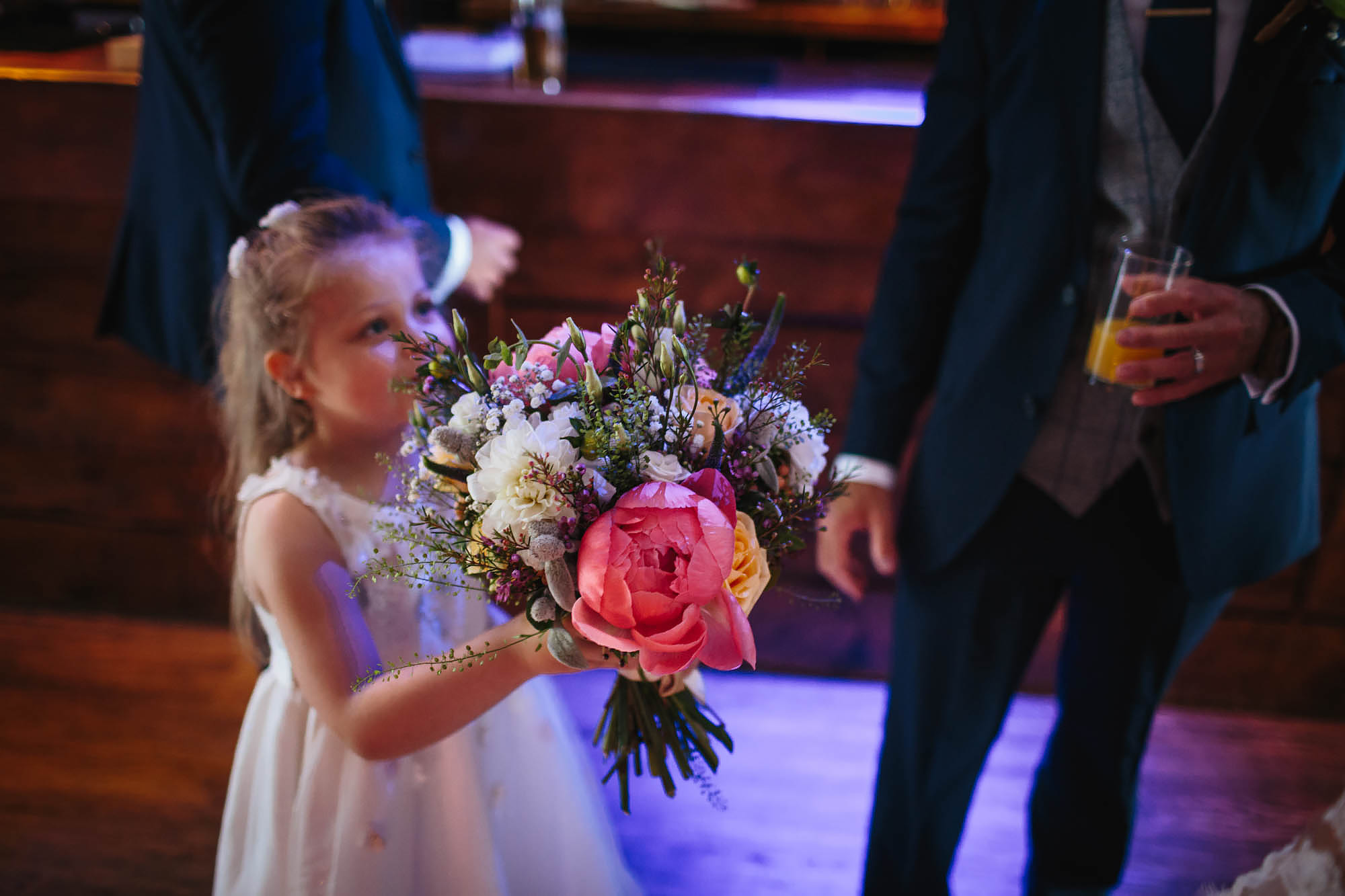 Flower girl holds the bouquet at a wedding
