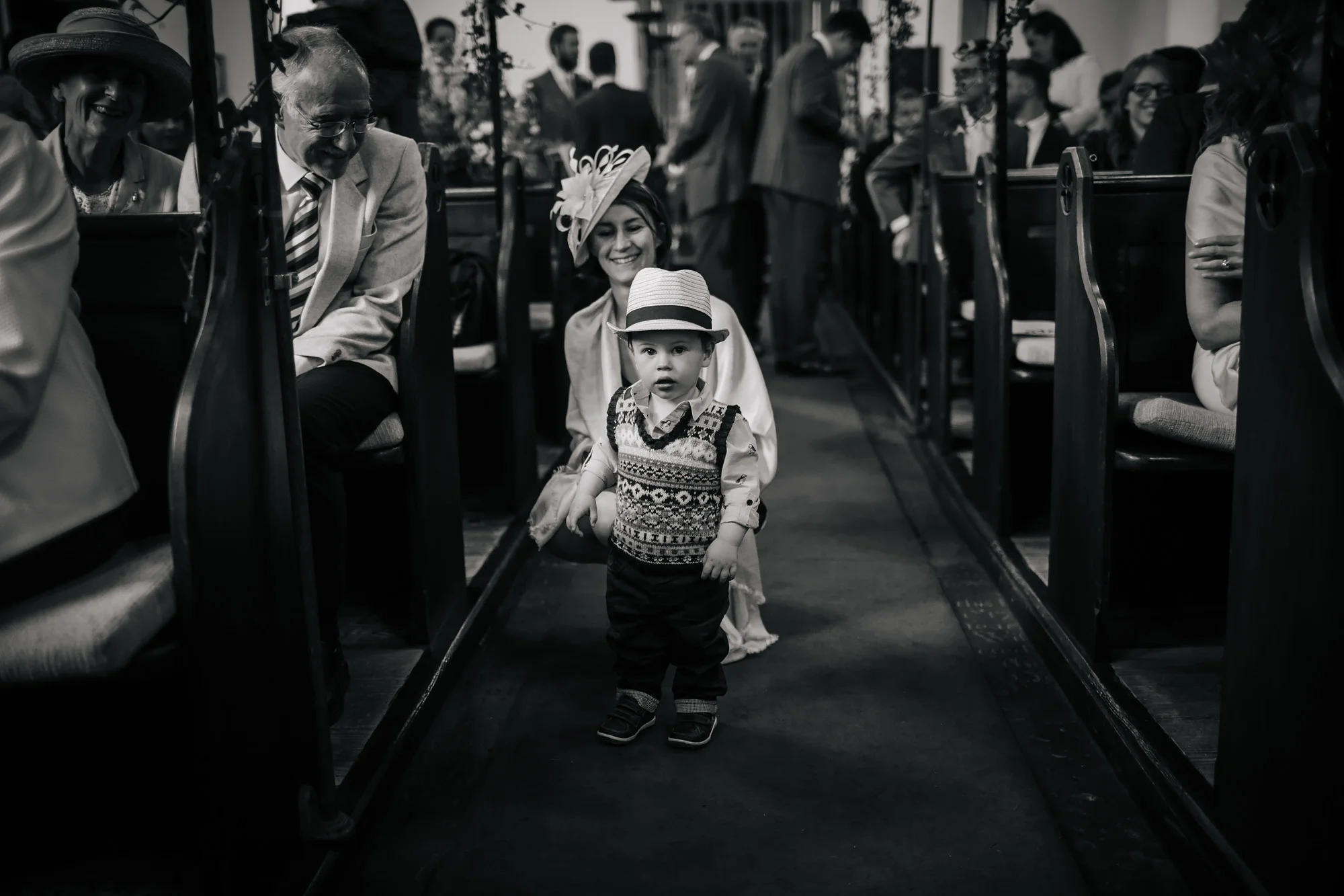 Boy with a hat in the church aisle during the wedding