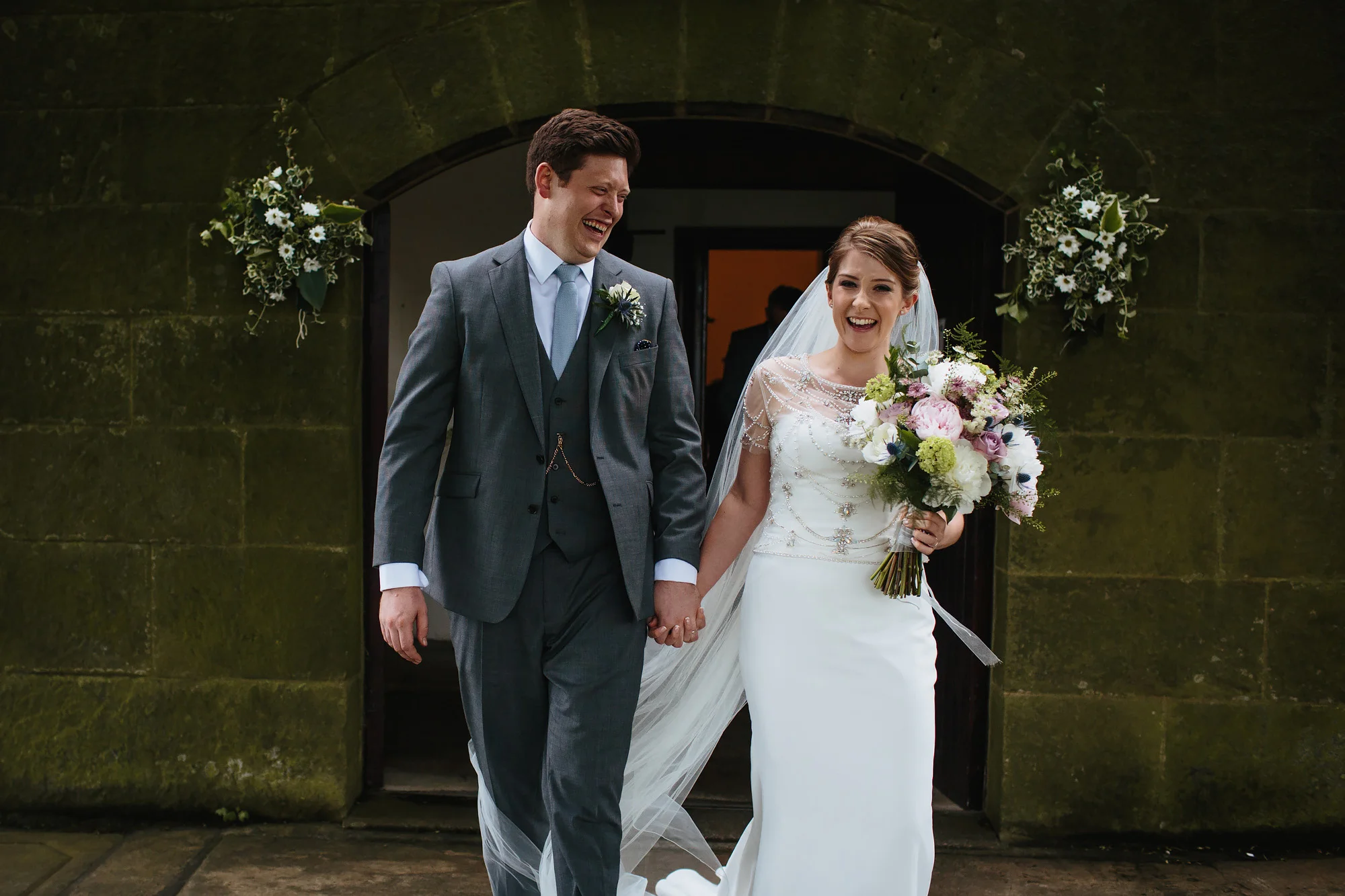 Married couple laughing as they exit the church