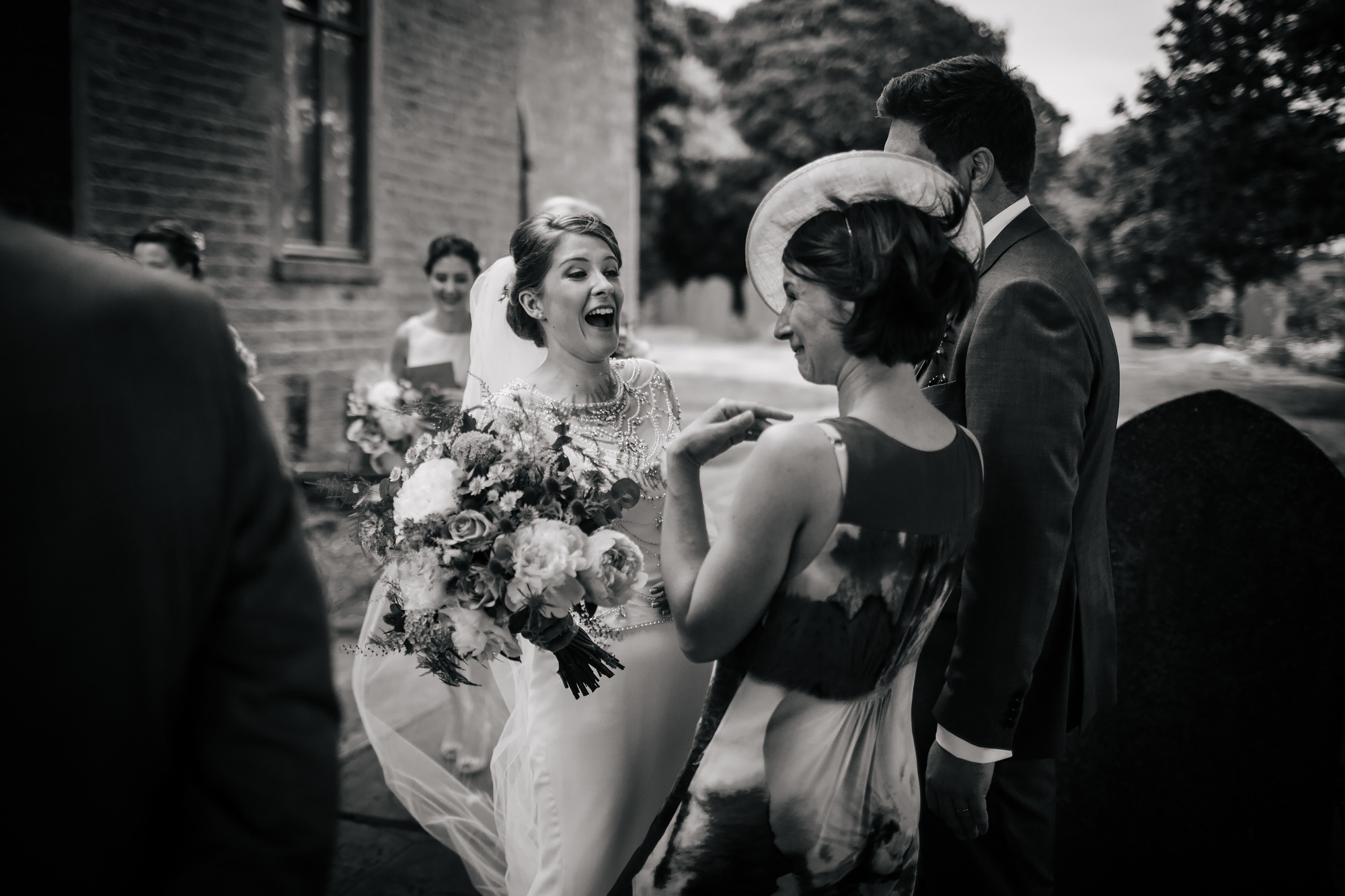 Bride laughing with guest outside the church
