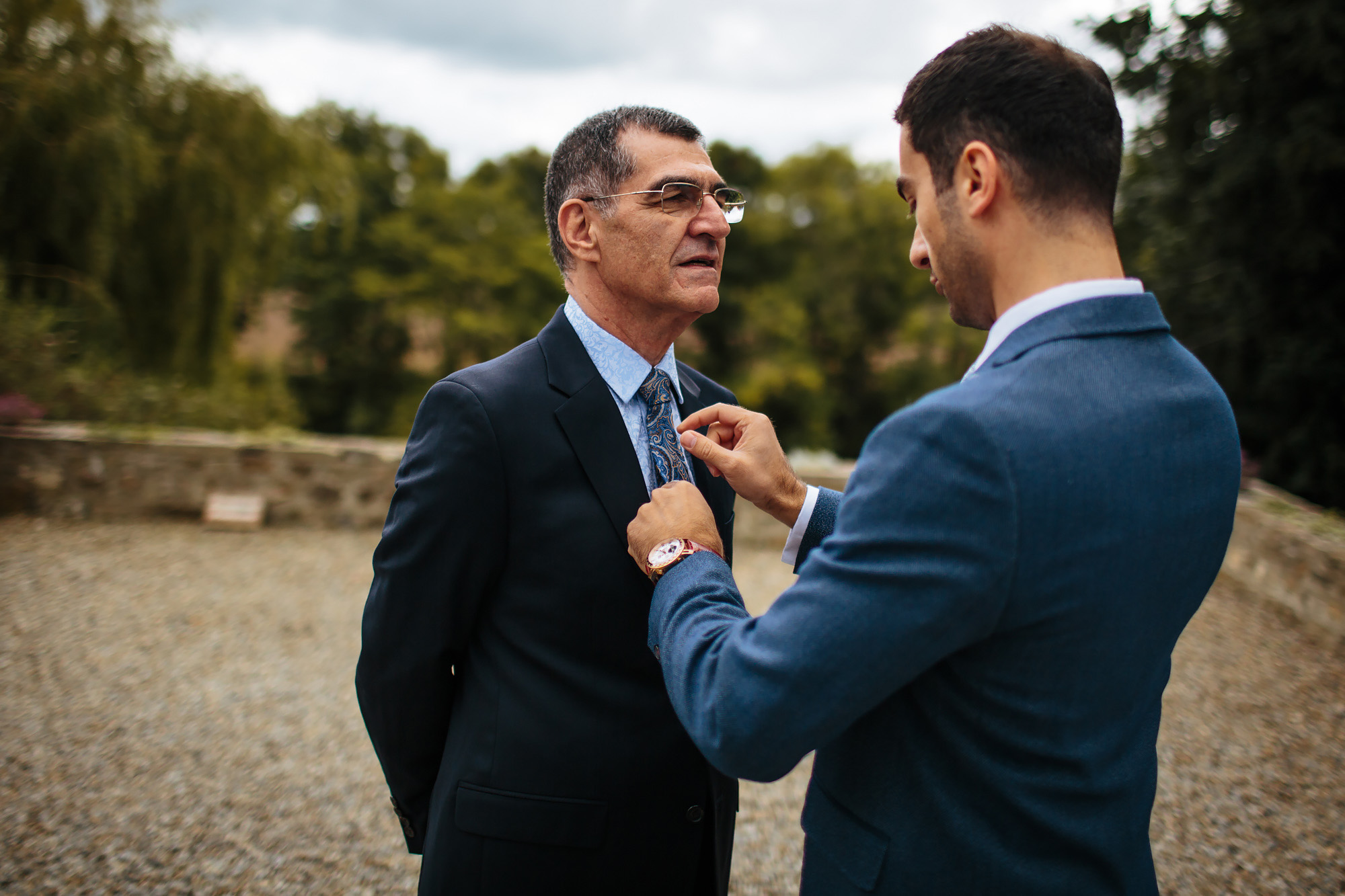 Groom adjusts fathers tie and suit for the wedding