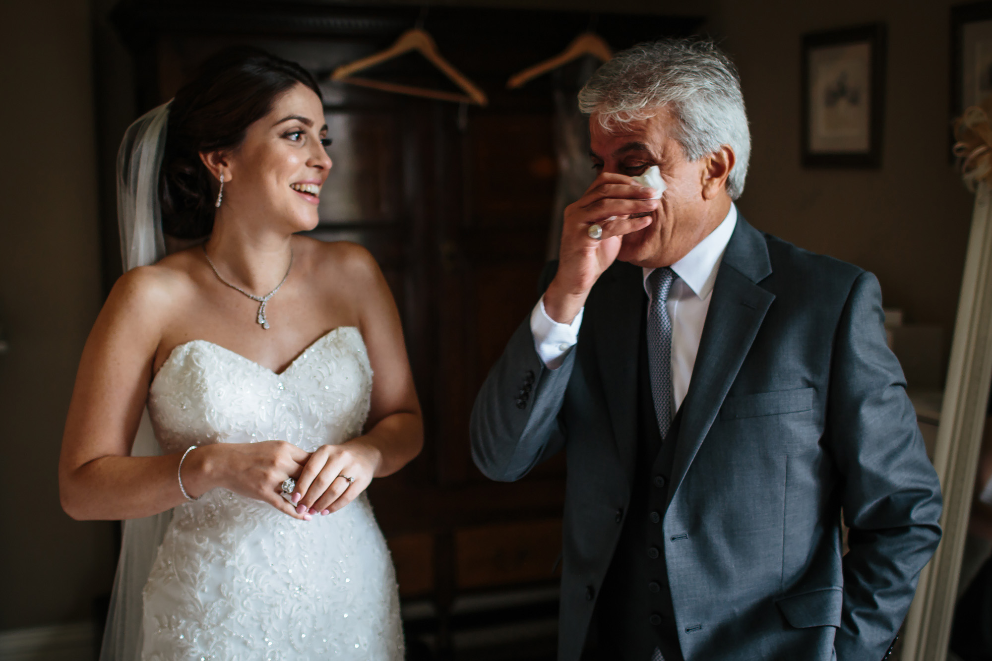 Brides father wipes away a tear and bride laughs