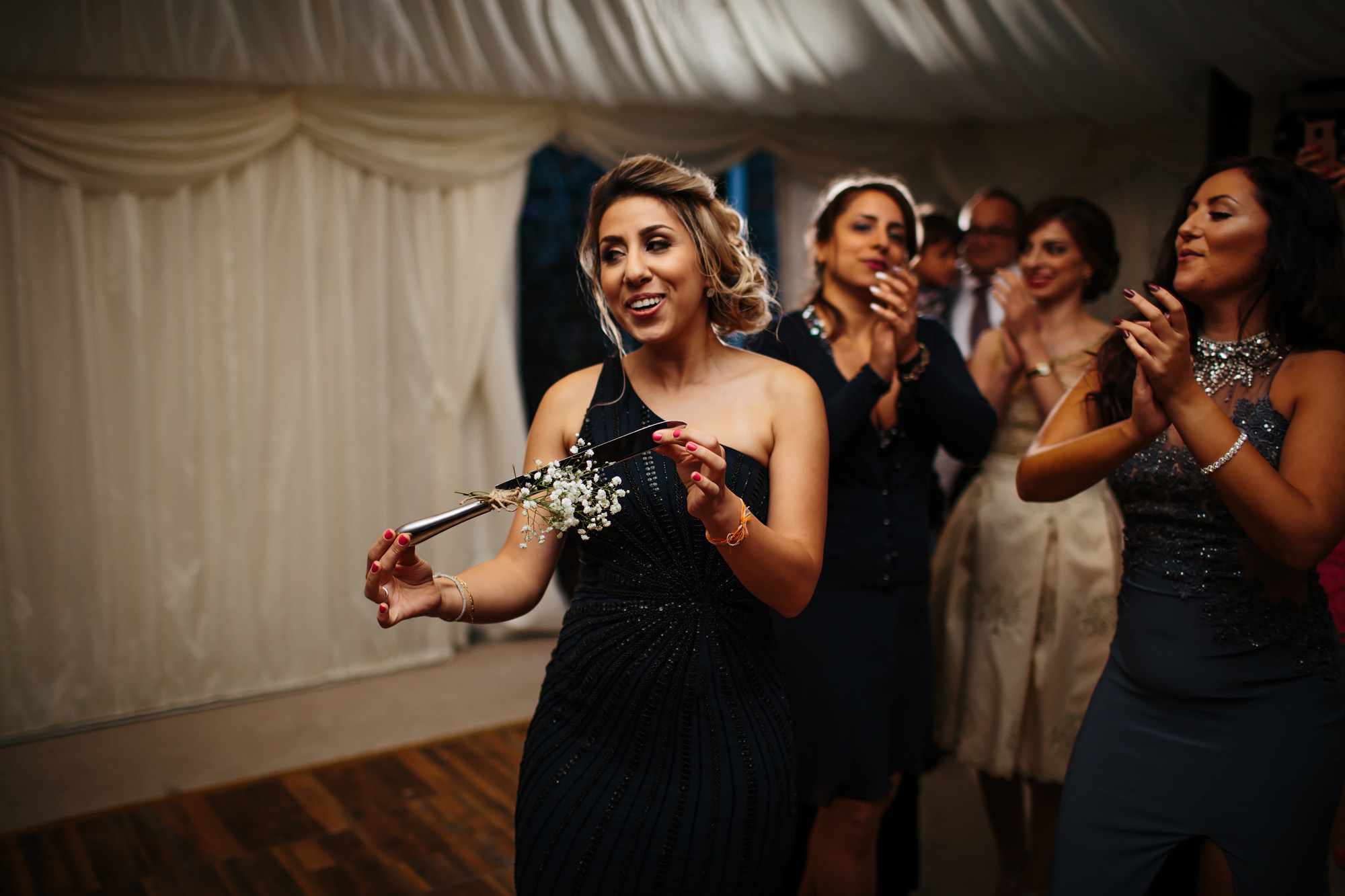 Bridesmaid dancing with the cake knife at a wedding