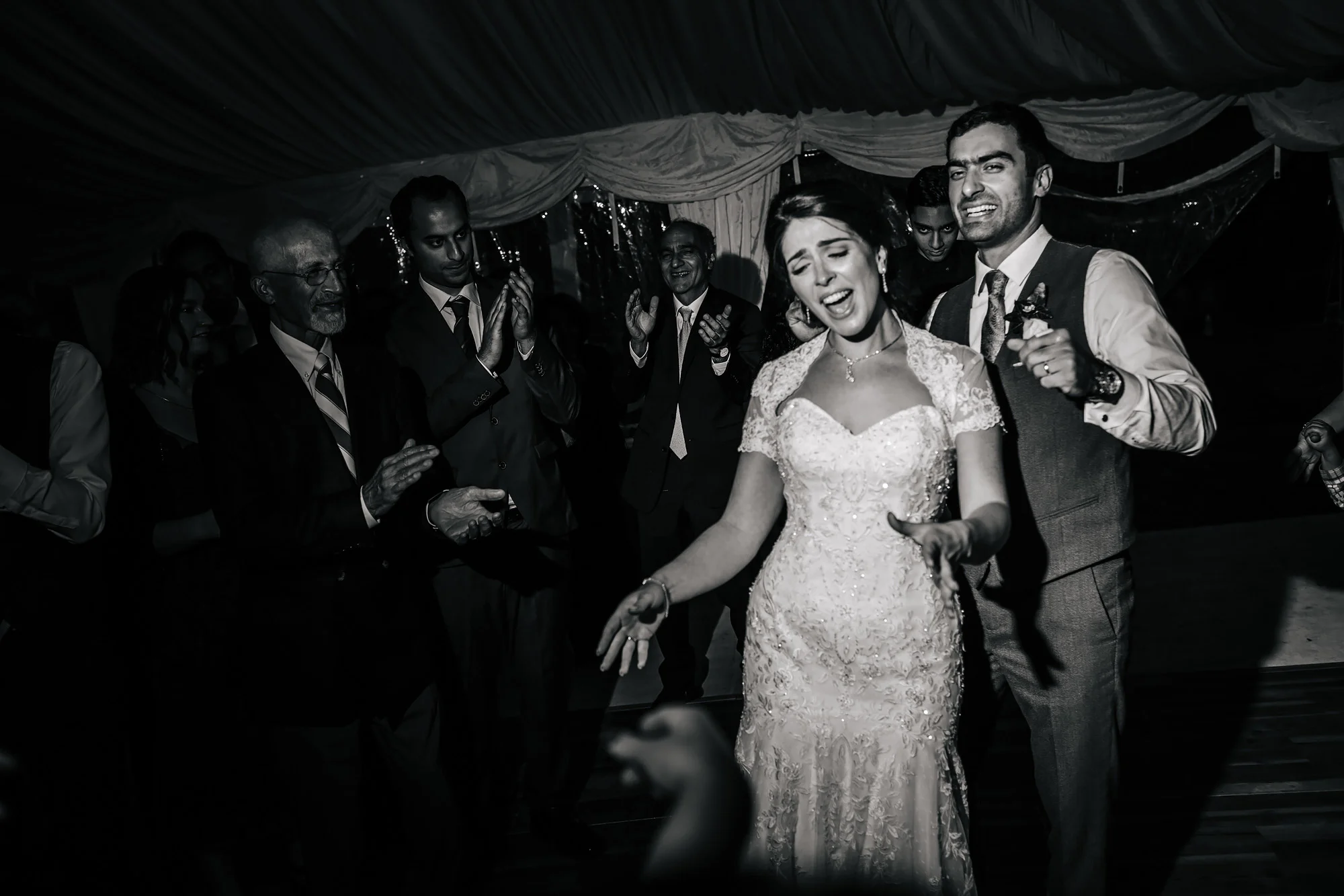 Happy couple laughing at their wedding and dancing
