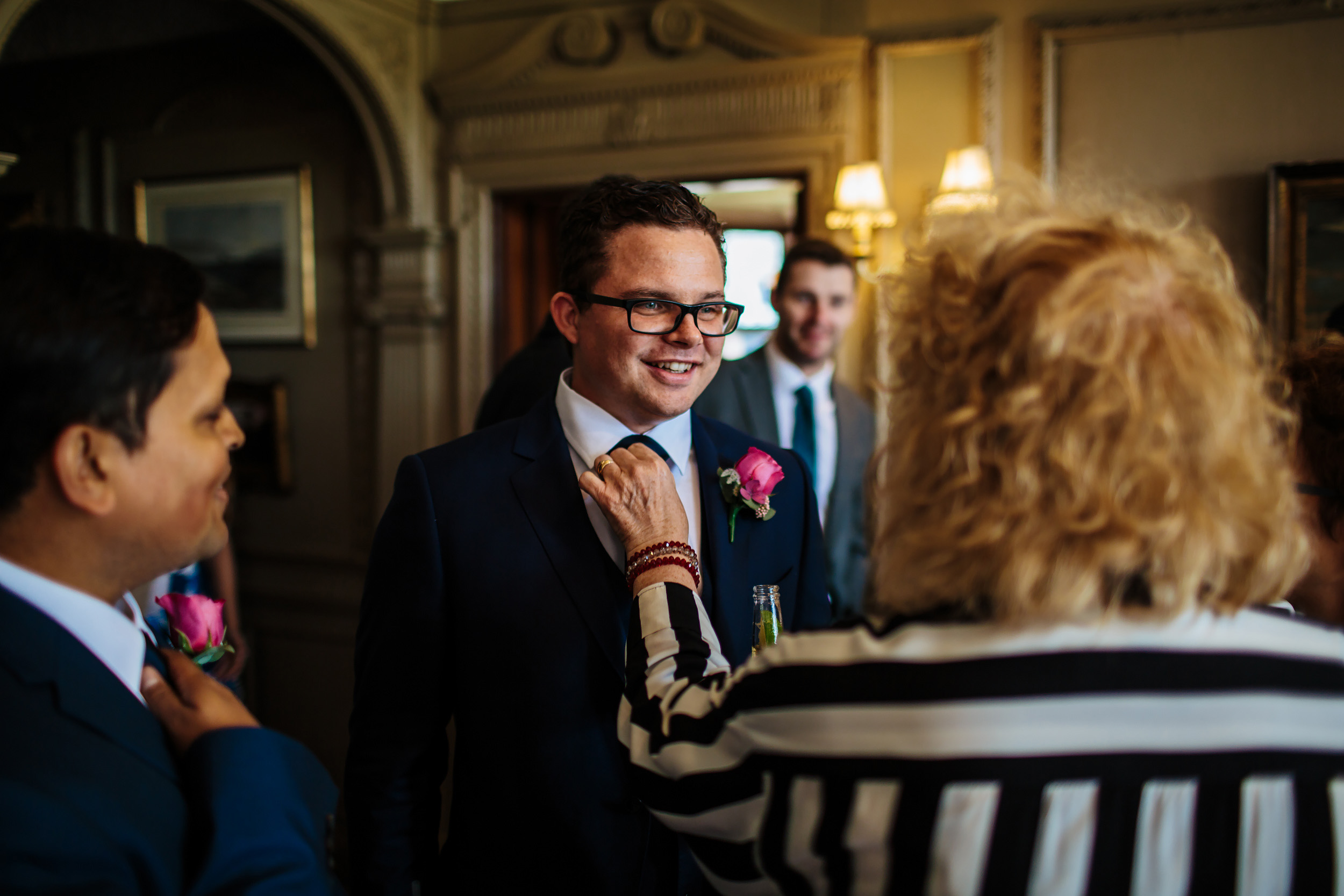 Grooms mother adjusts his tie at a wedding in Cheshire